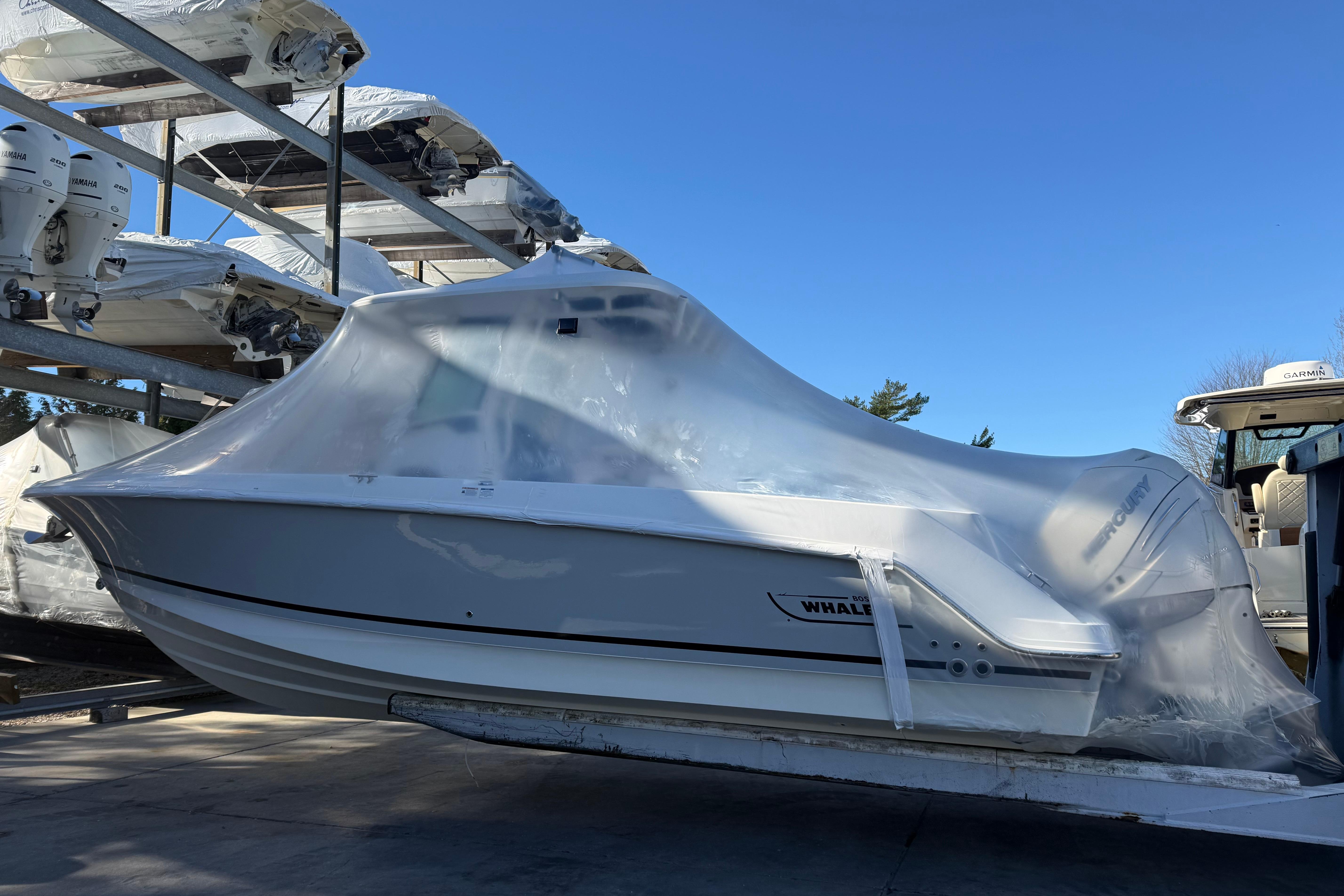 2017 Boston Whaler 280 Outrage boat covered in protective wrap, stored outdoors.