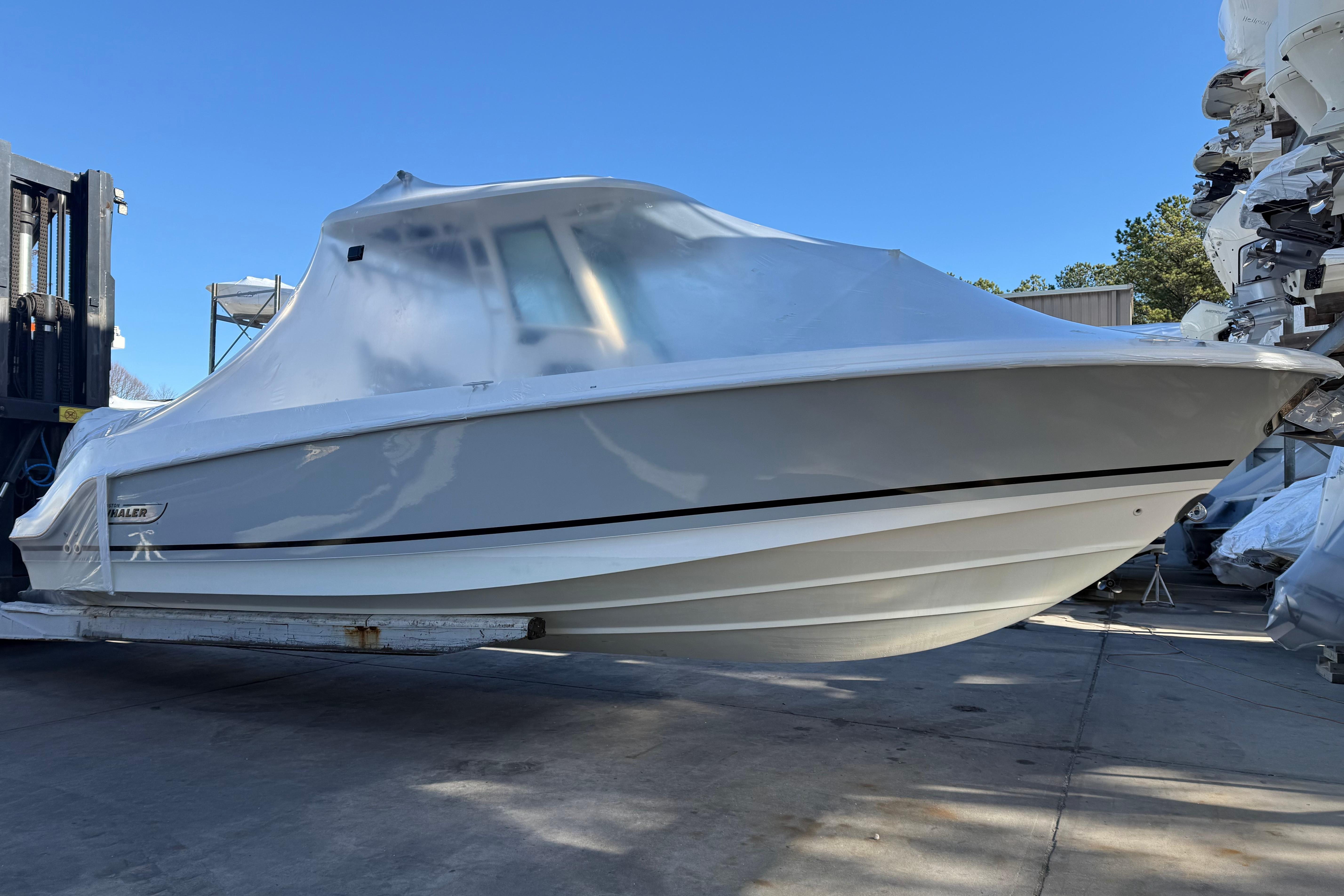 2017 Boston Whaler 280 Outrage boat covered in protective wrap, stored outdoors.
