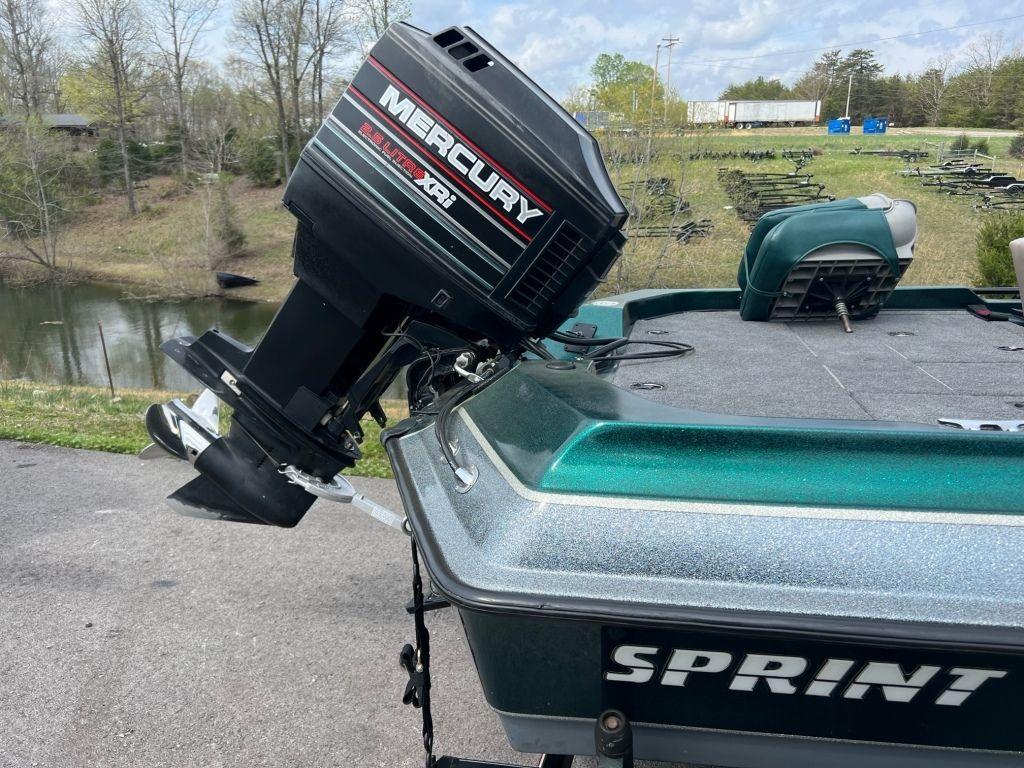 1999 Sprint 286 Pro boat with Mercury XRi outboard motor near a lake.