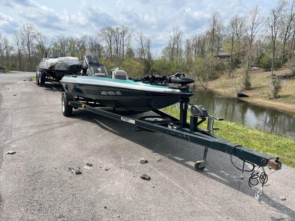 1999 Sprint 286 Pro boat on trailer near a lake, ready for transport.