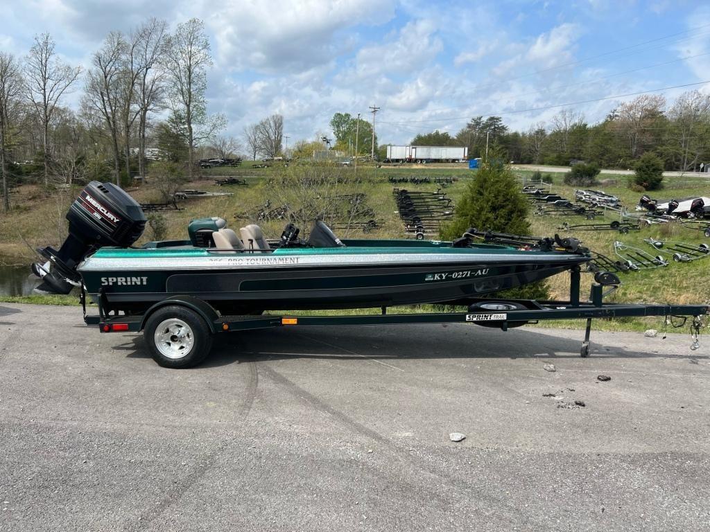 1999 Sprint 286 Pro boat on trailer with outboard motor in a rural setting.