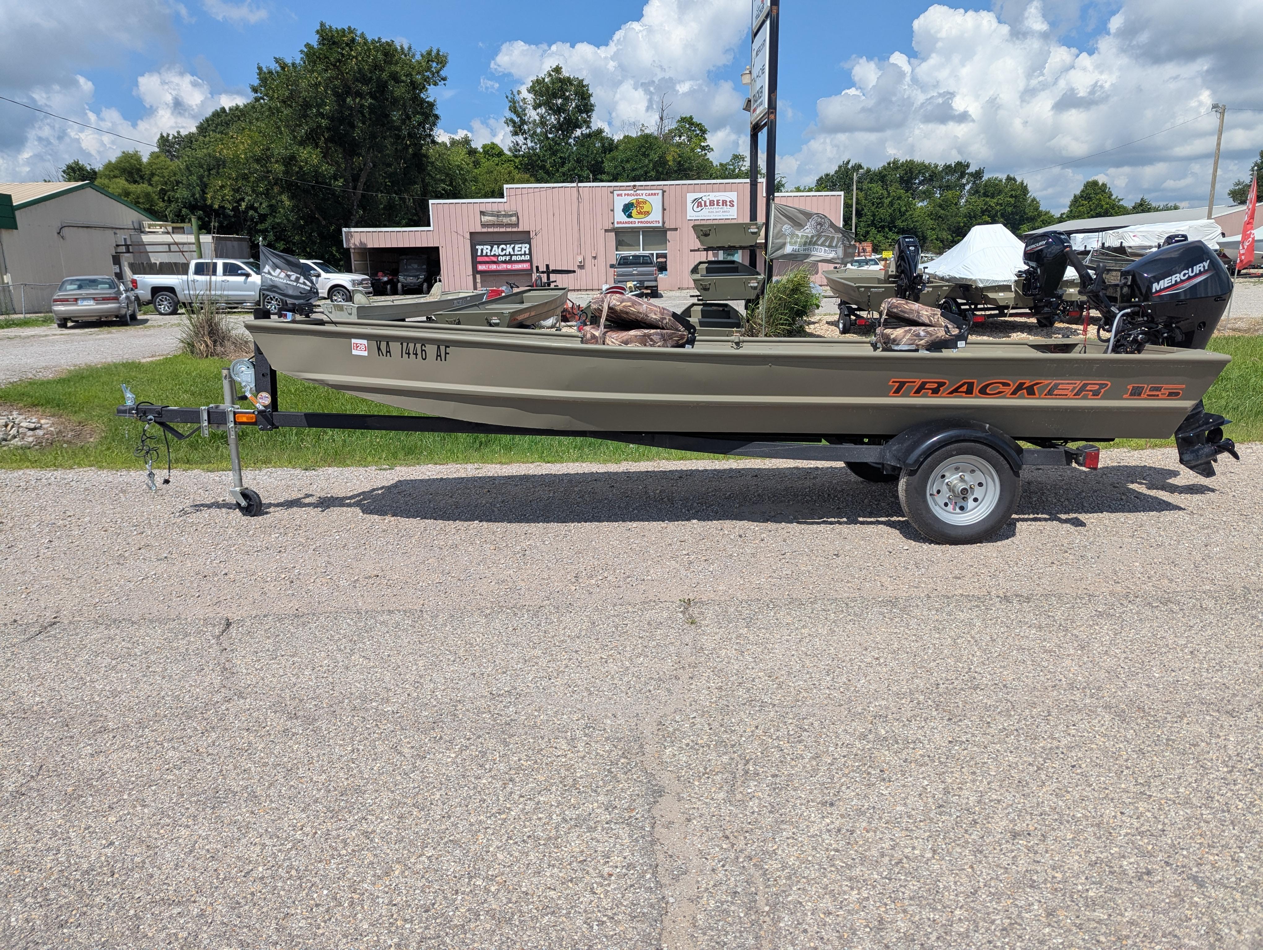 2025 Tracker Grizzly 15 Jon boat on trailer, parked outdoors under a blue sky.