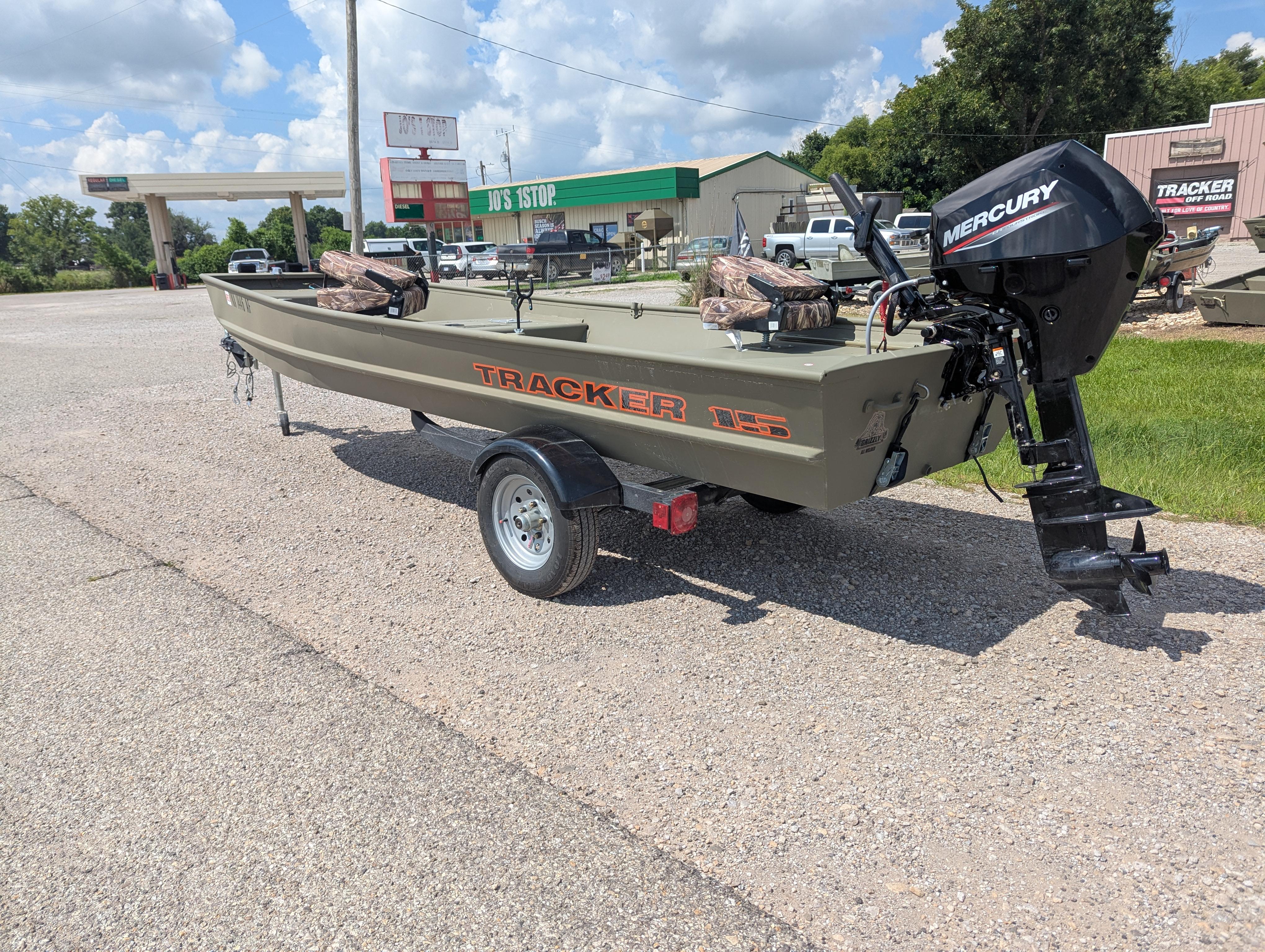 2025 Tracker Grizzly 15 Jon boat with Mercury motor on trailer, parked outdoors.