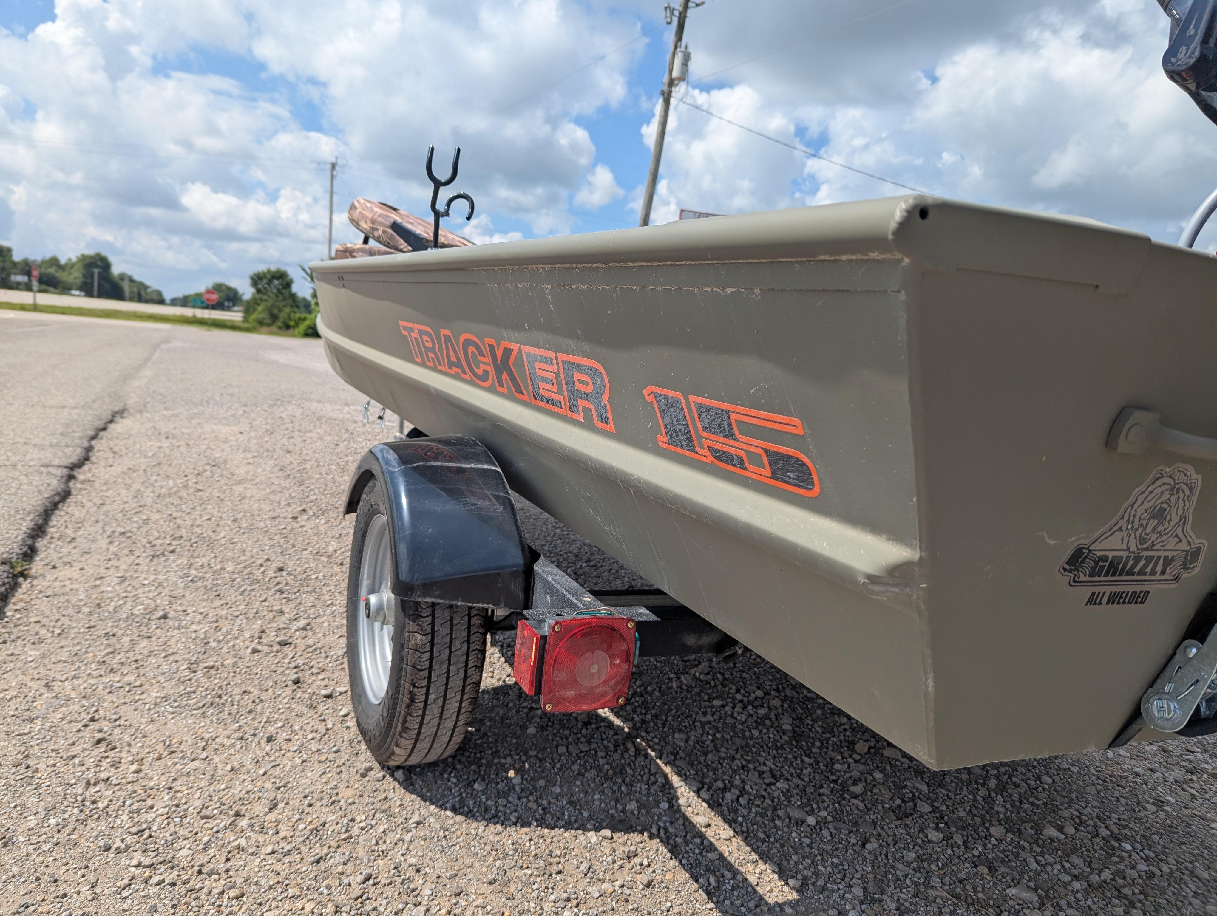 2025 Tracker Grizzly 15 Jon boat on trailer, parked on a sunny day.