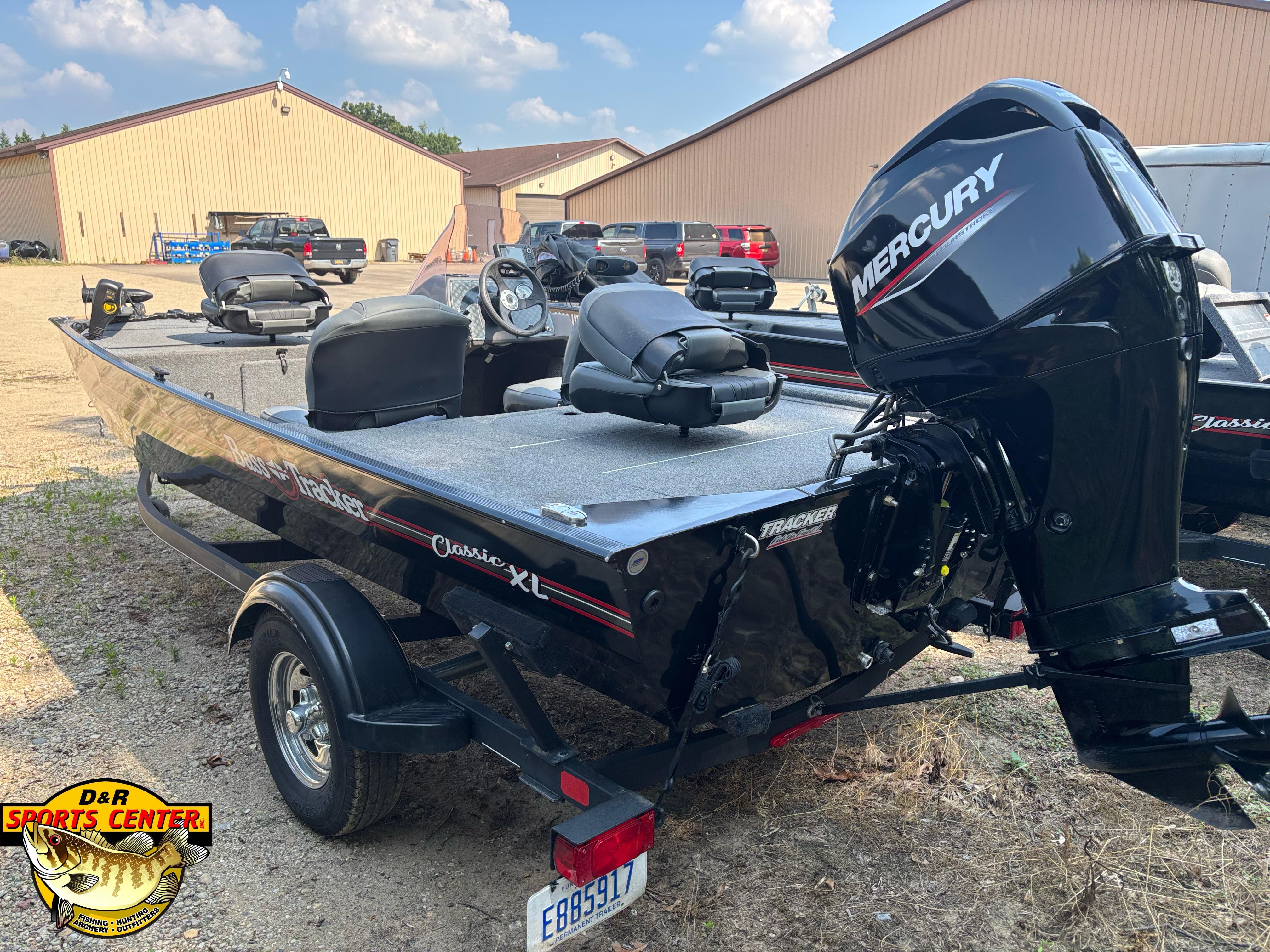 2021 Tracker Bass Tracker Classic XL boat with Mercury engine, parked outdoors near buildings.