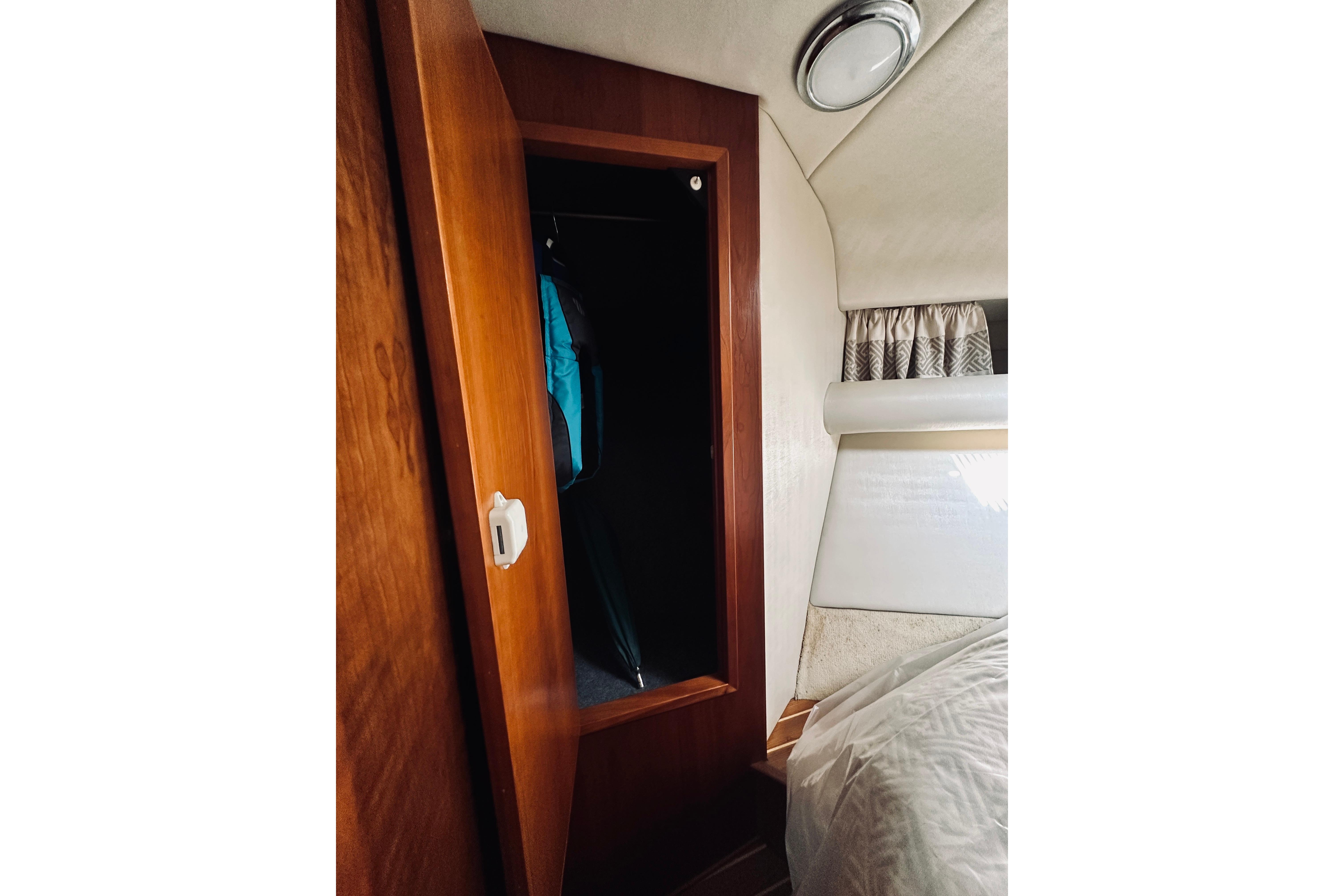 Interior of 2000 Riviera 40 yacht showing wooden closet and cozy bedroom.