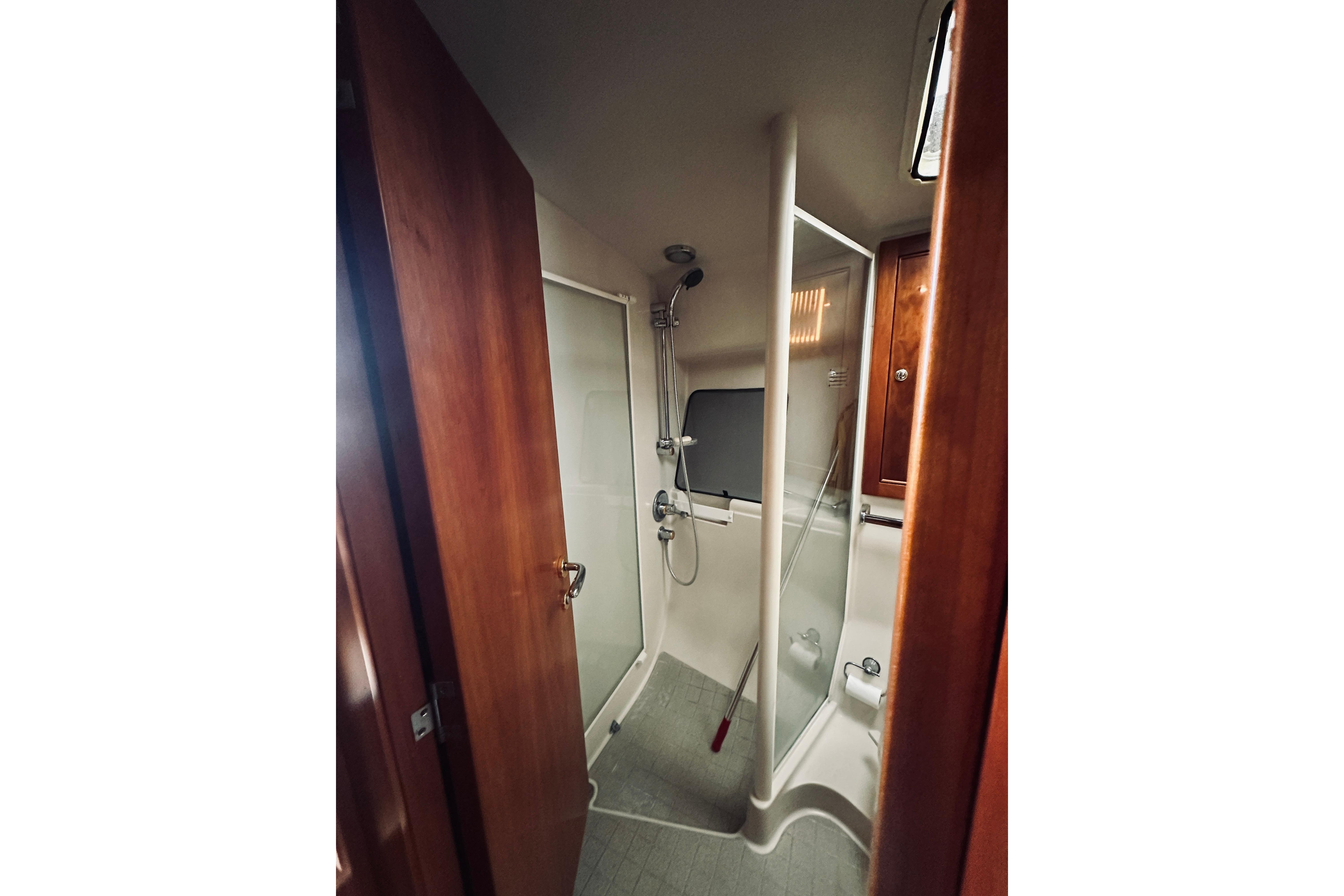 Bathroom interior of 2000 Riviera 40 yacht with shower and wooden cabinetry.