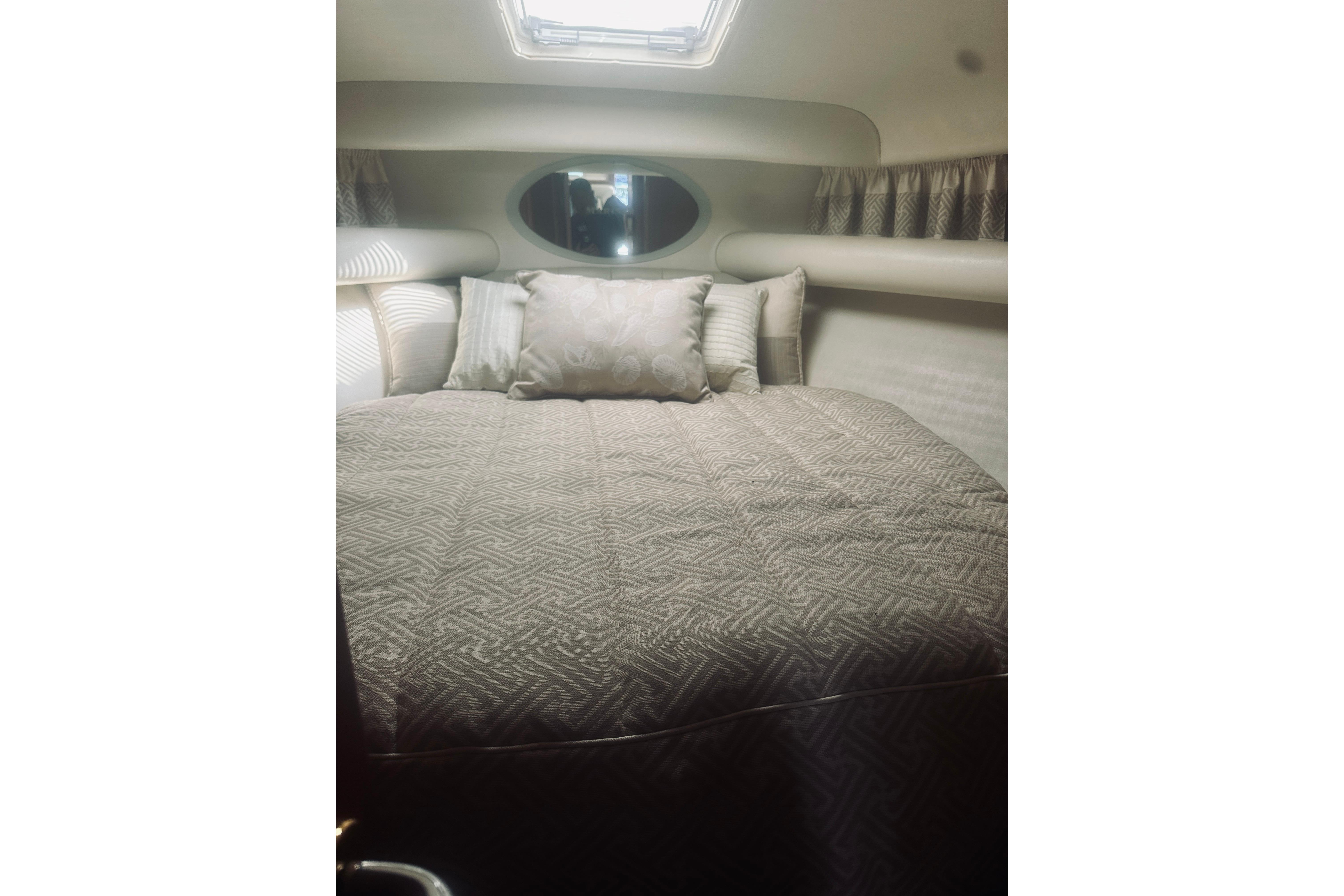 Interior cabin of 2000 Riviera 40 yacht with cozy bed and pillows.