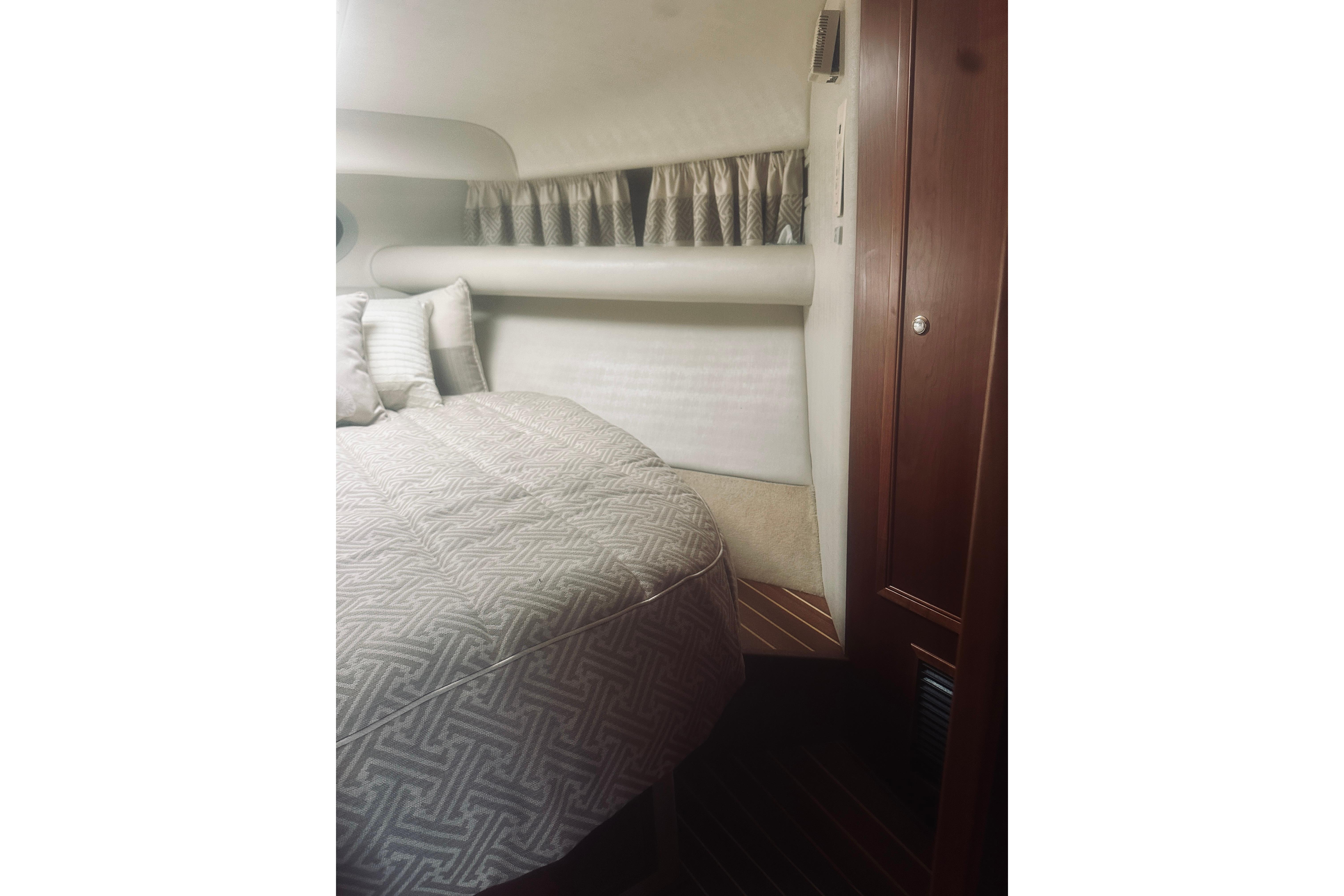 Interior cabin of 2000 Riviera 40 yacht with cozy bed and wooden accents.