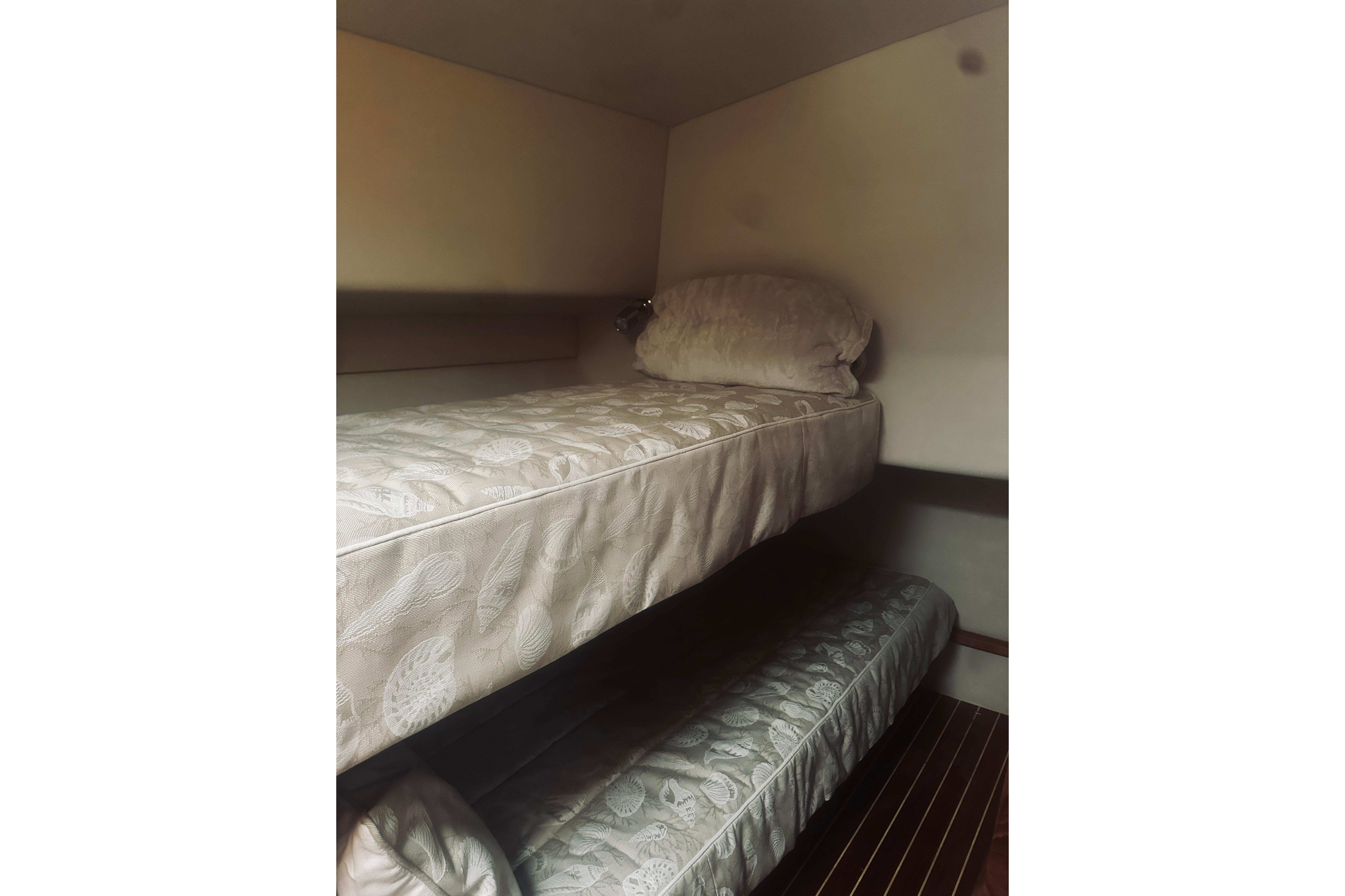 Bunk beds in 2000 Riviera 40 yacht cabin, featuring patterned mattresses and cozy interior.