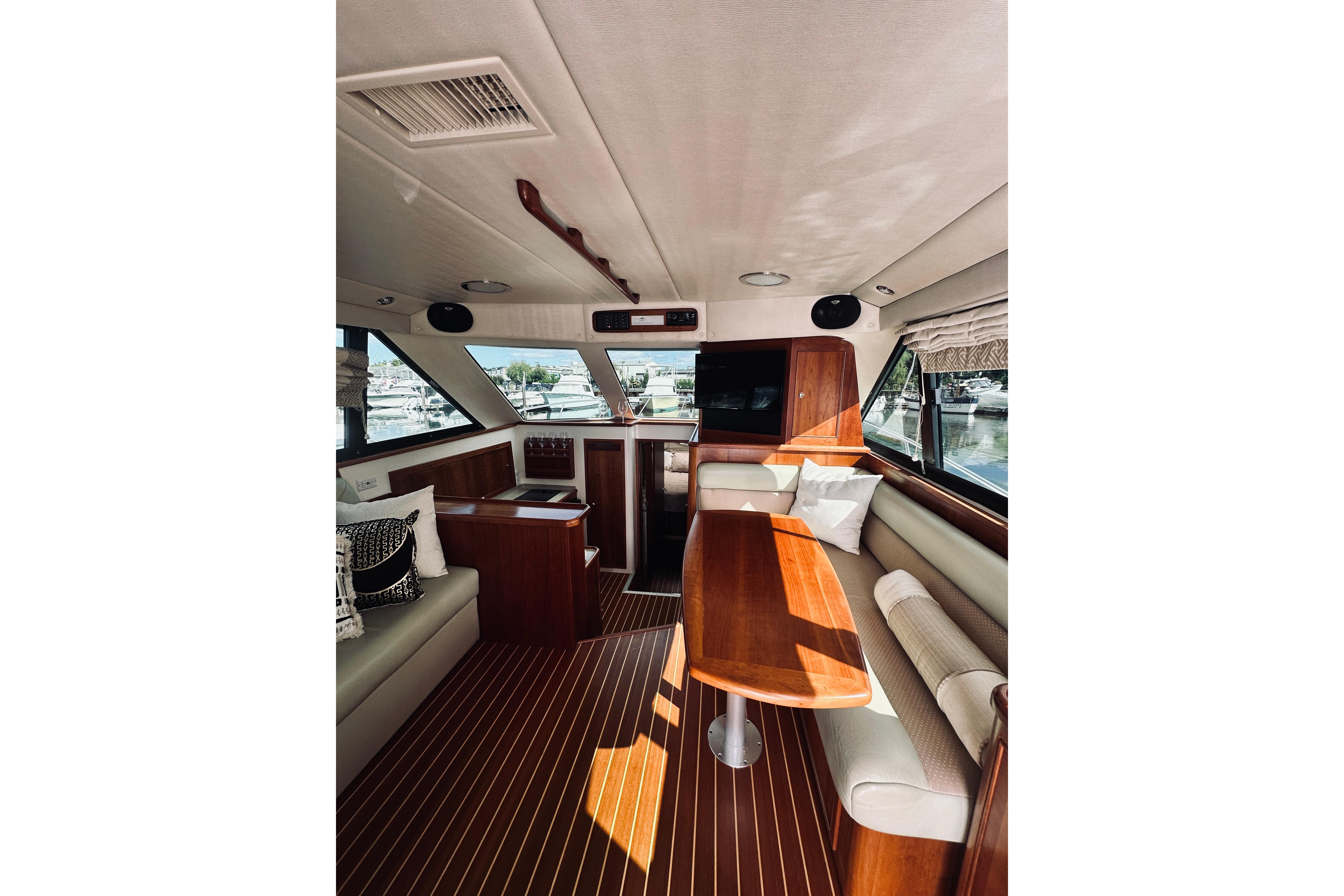 Luxurious interior of 2000 Riviera 40 yacht with elegant wood finishes and comfortable seating.