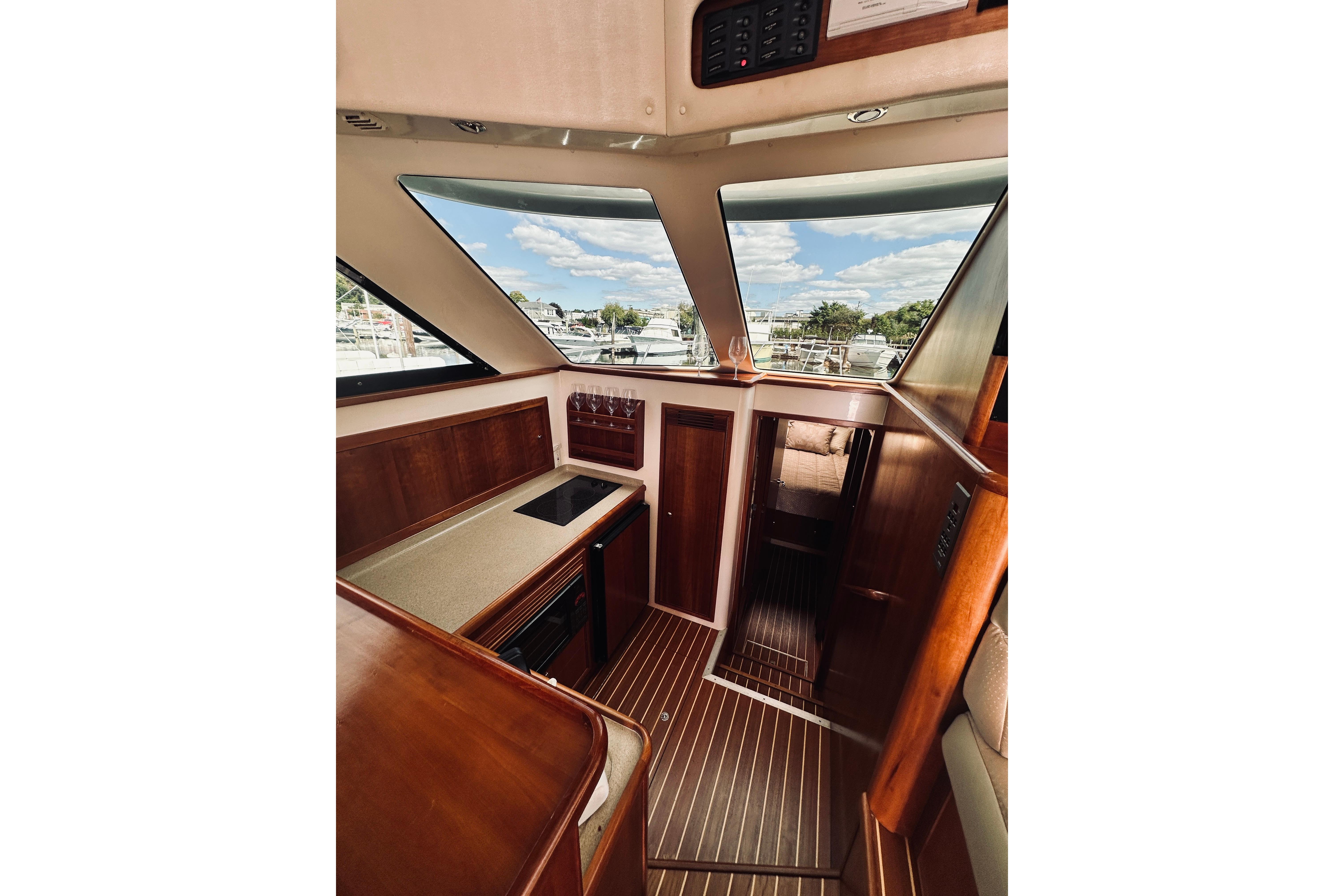 Interior of 2000 Riviera 40 yacht with wooden finishes and large windows.