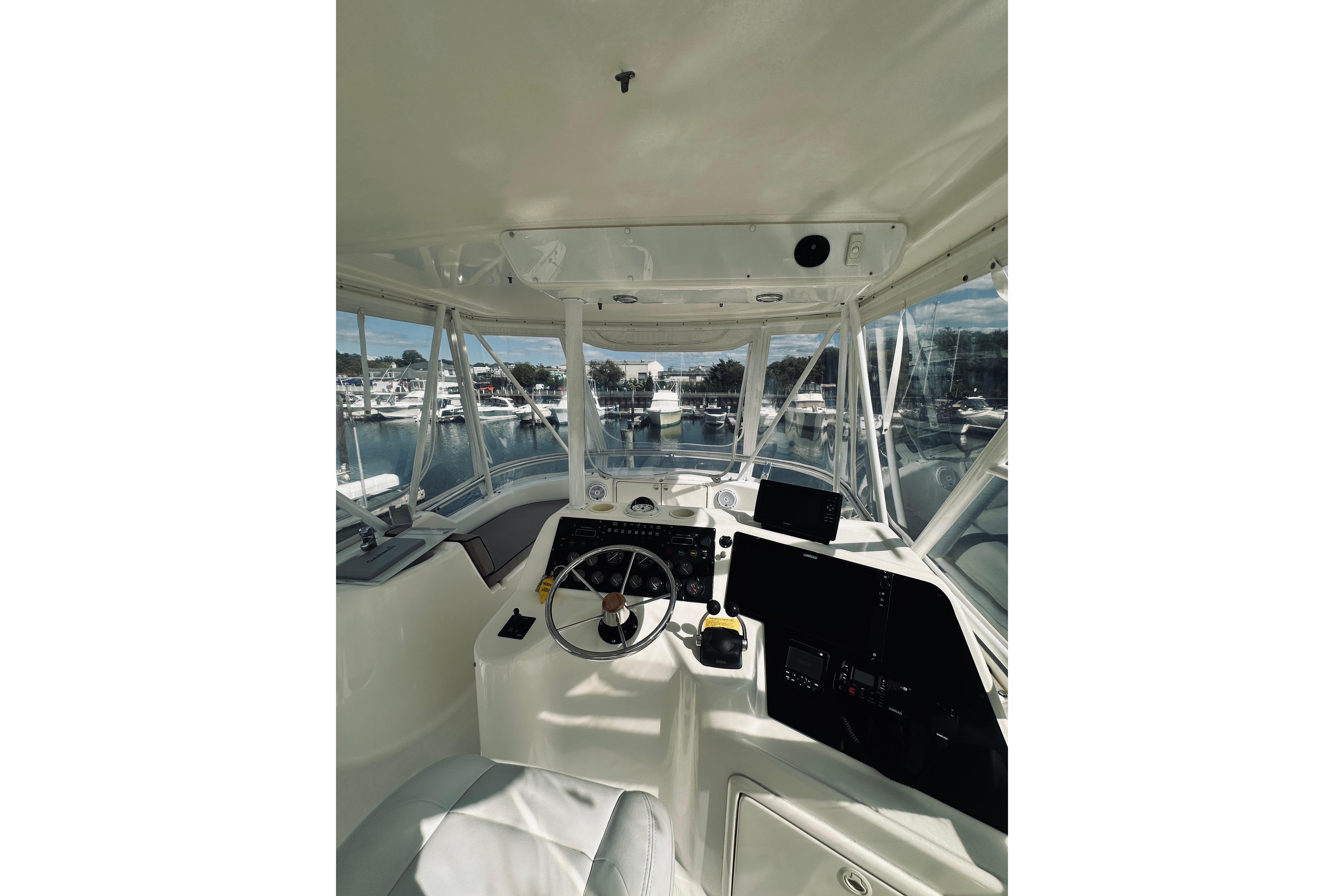 Interior view of 2000 Riviera 40 yacht cockpit with steering wheel and navigation equipment.