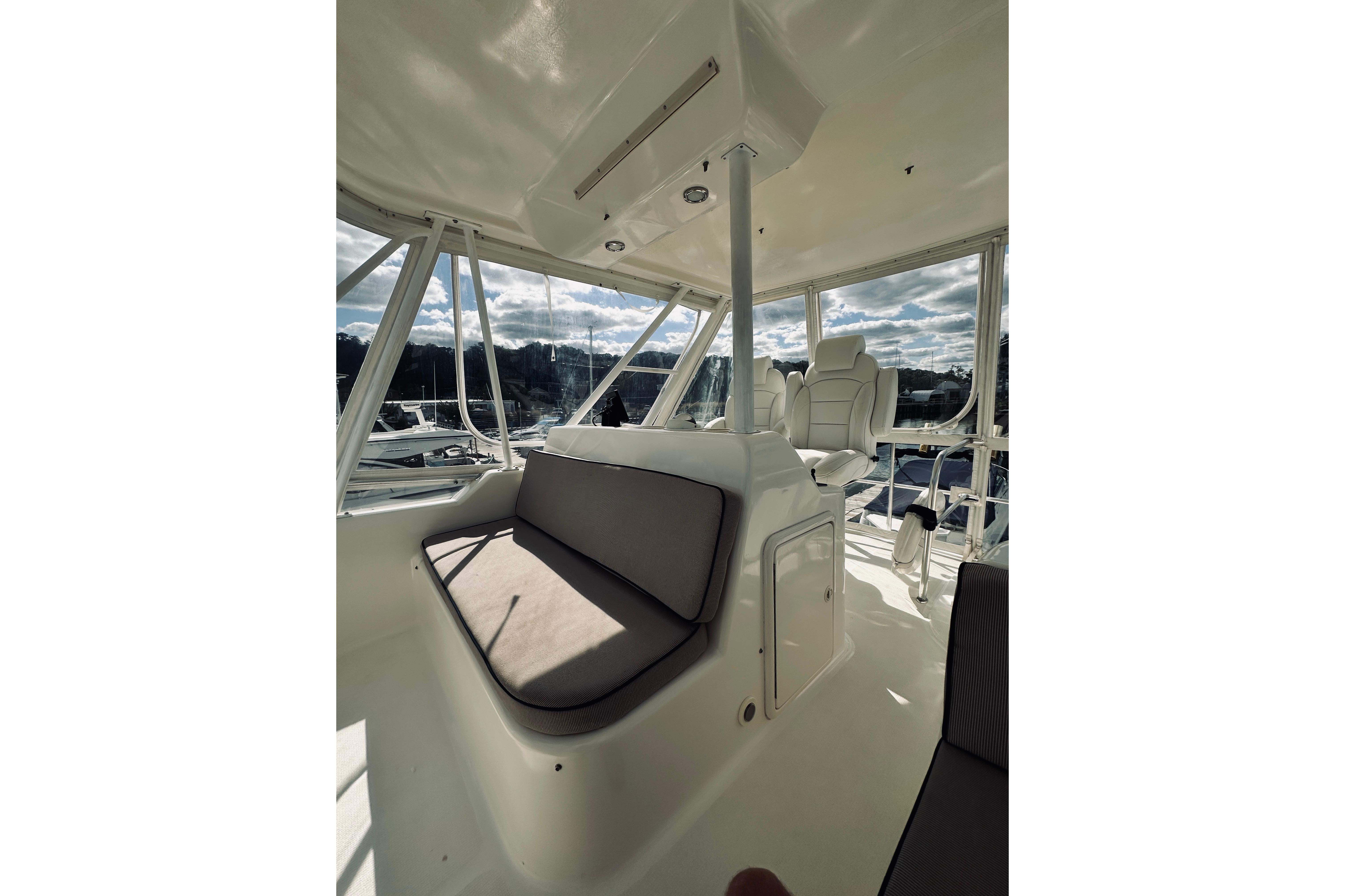 Interior of 2000 Riviera 40 yacht with cushioned seating and panoramic windows.