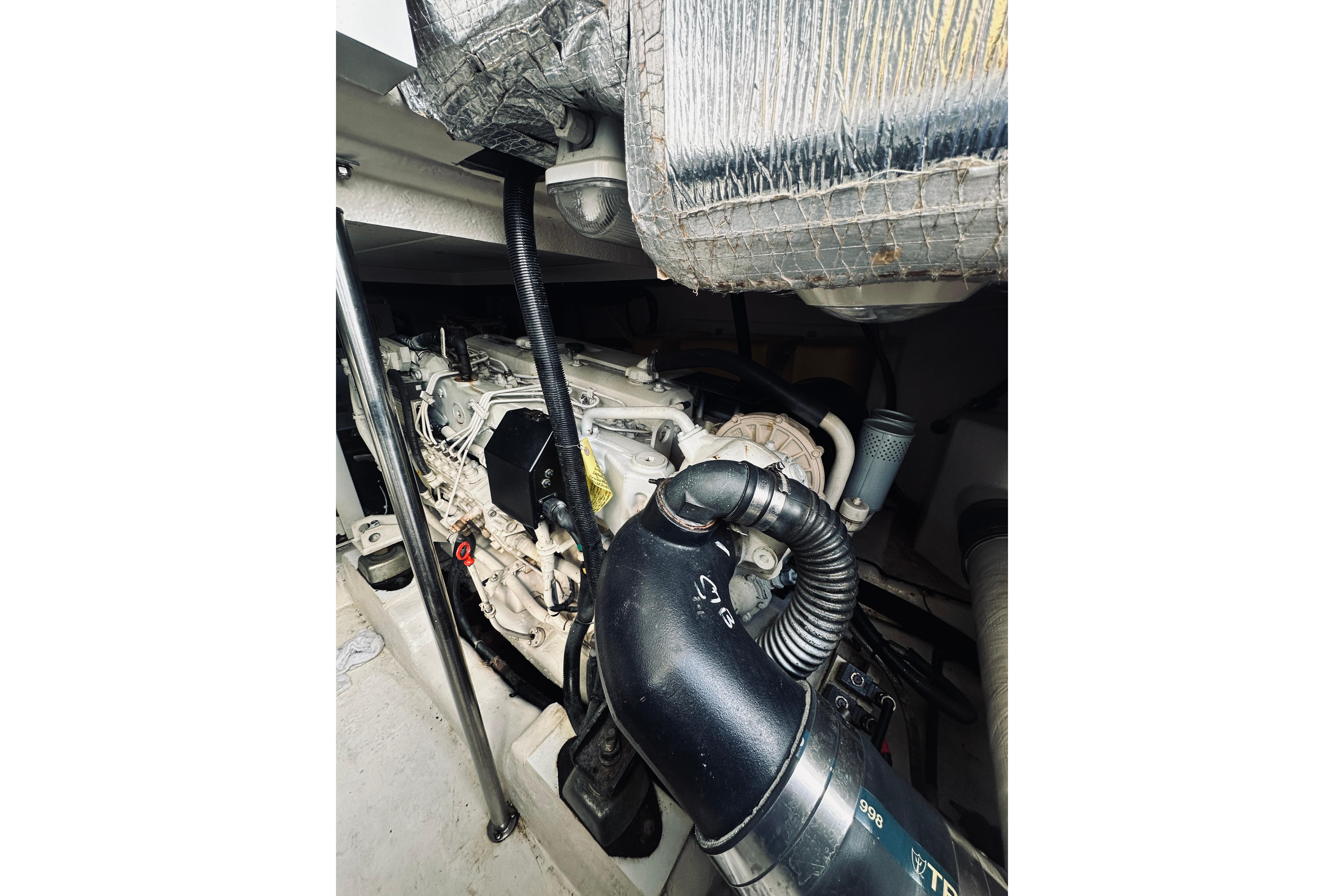 Engine compartment of a 2000 Riviera 40 boat, showcasing mechanical components and piping.