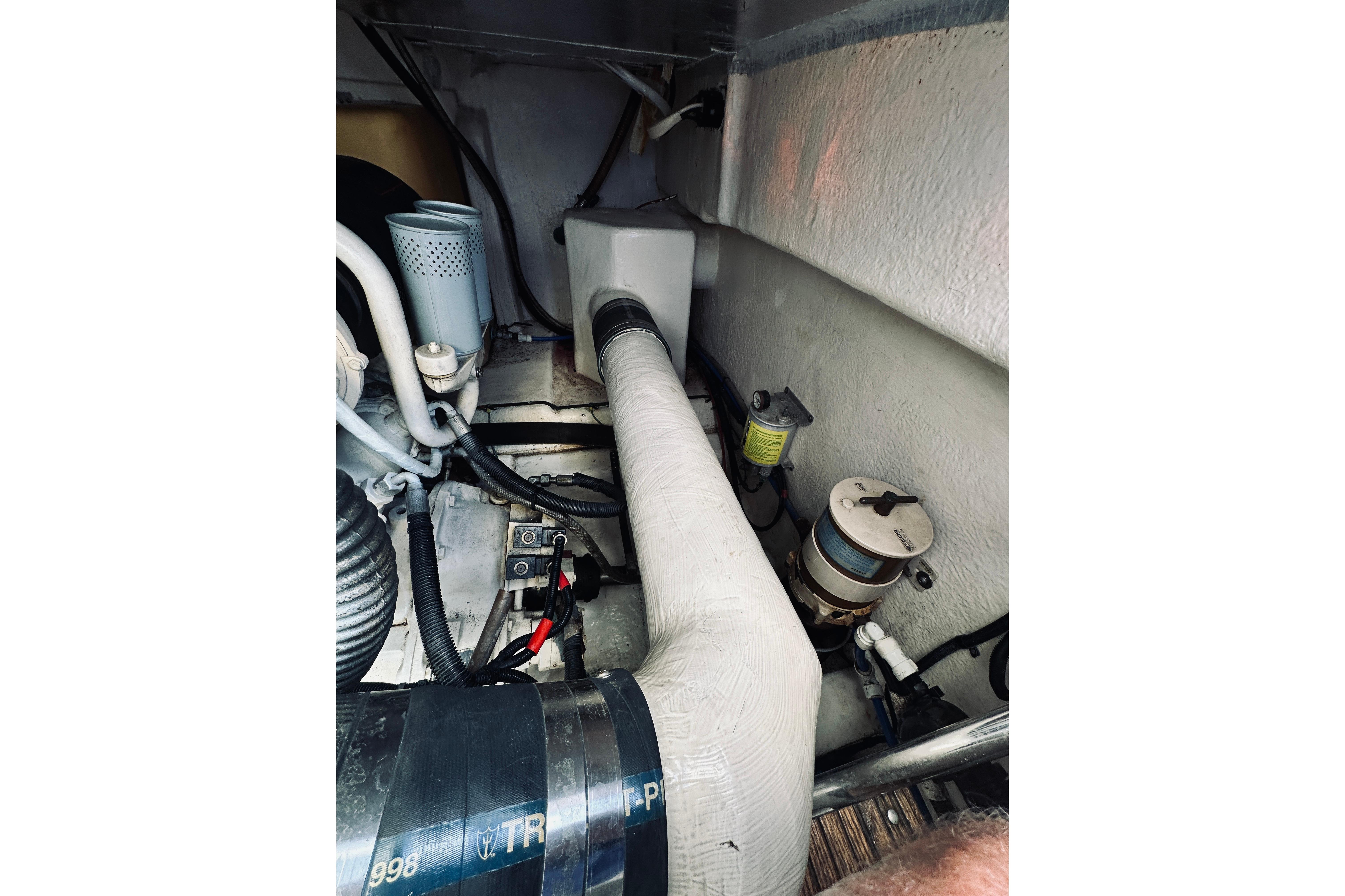 Engine compartment of a 2000 Riviera 40 boat, showcasing mechanical components and hoses.