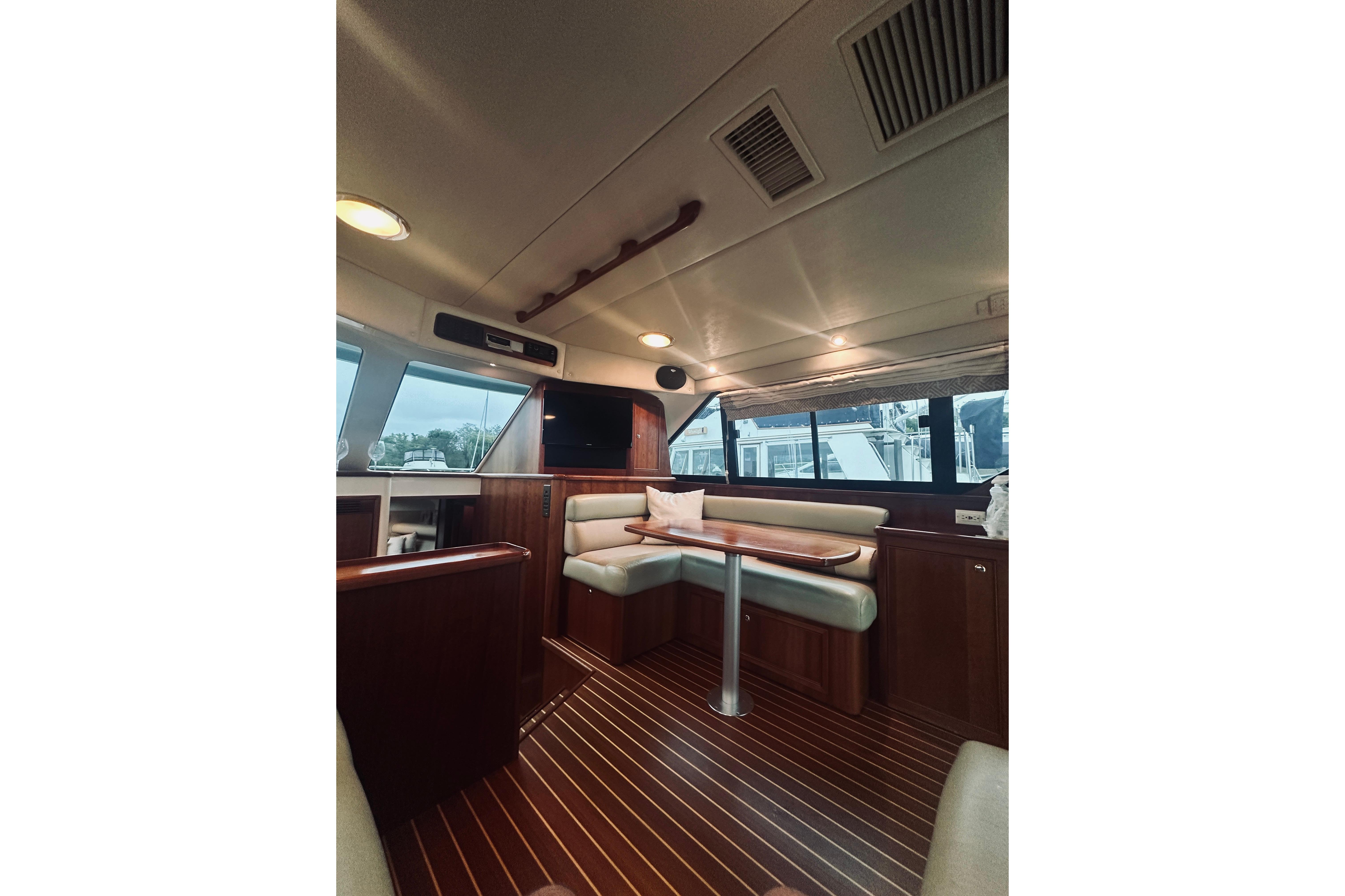 Interior of 2000 Riviera 40 yacht with elegant wood finish and seating area.