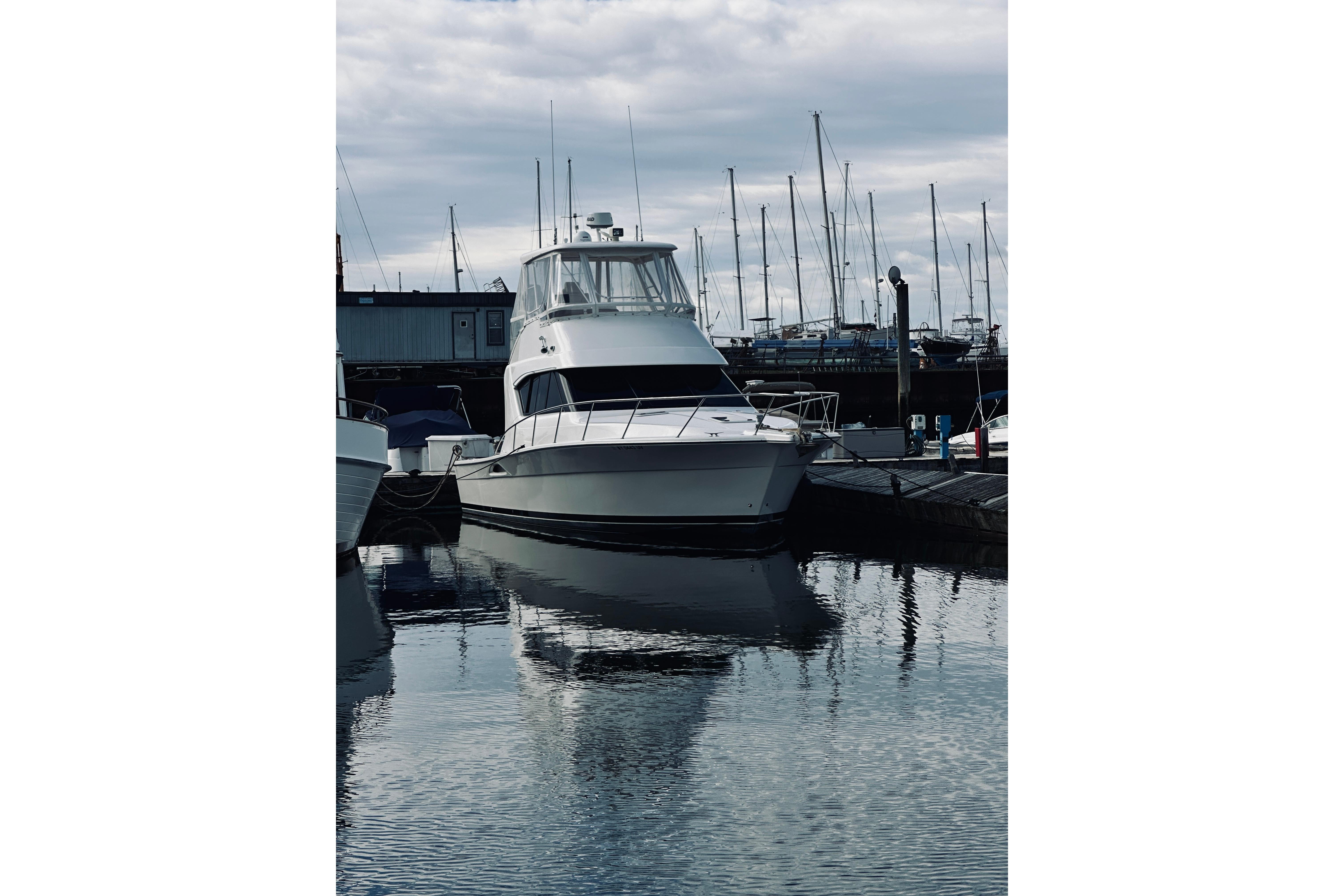 Riviera 40 yacht from 2000 docked at a marina with sailboats in the background.
