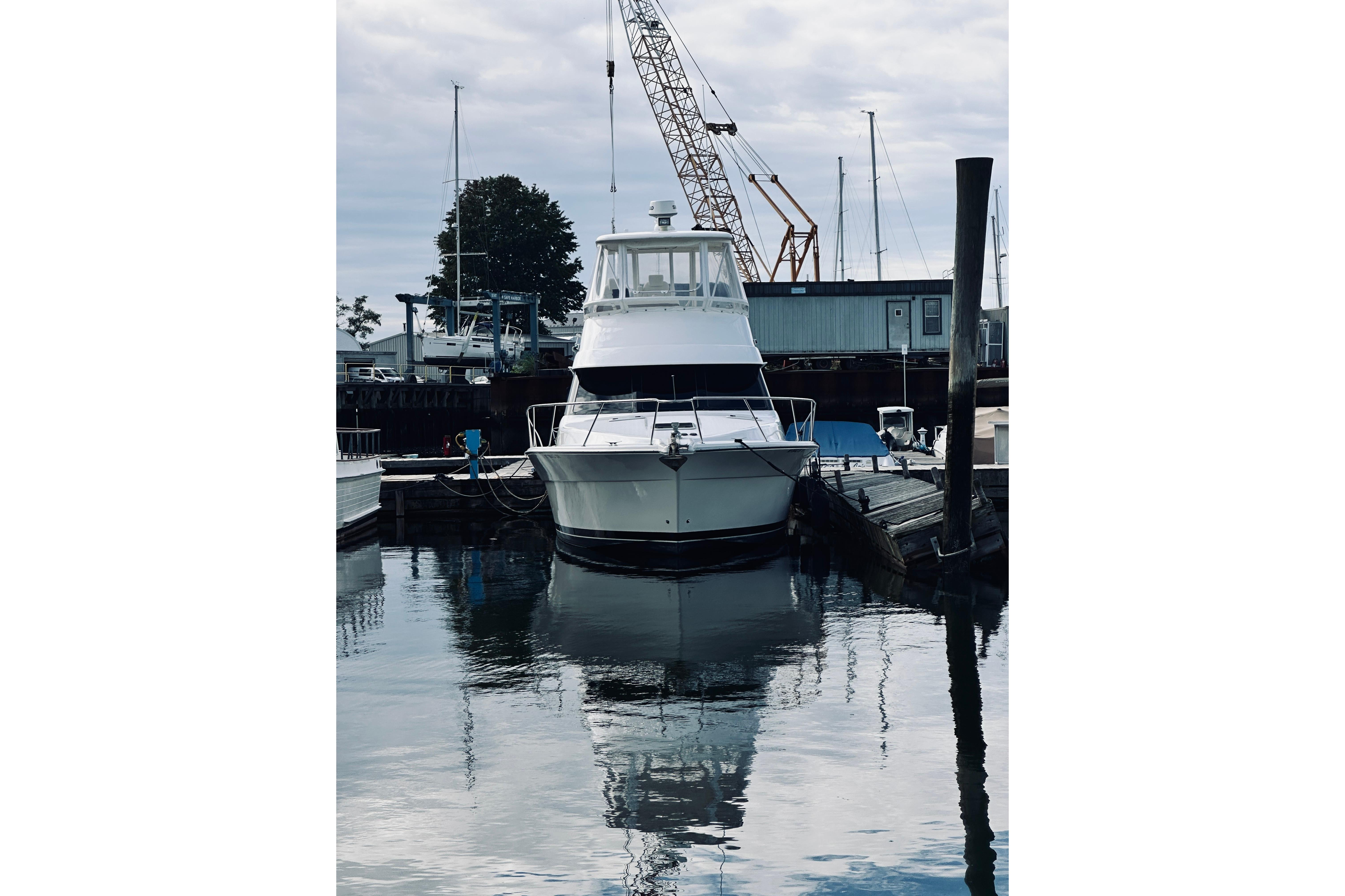 2000 Riviera 40 yacht docked at marina with cranes in background.