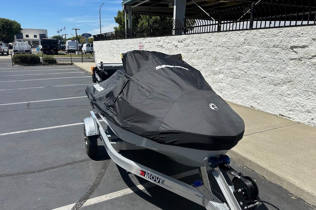 2023 Sea-Doo Fish Pro Trophy covered on trailer in parking lot.