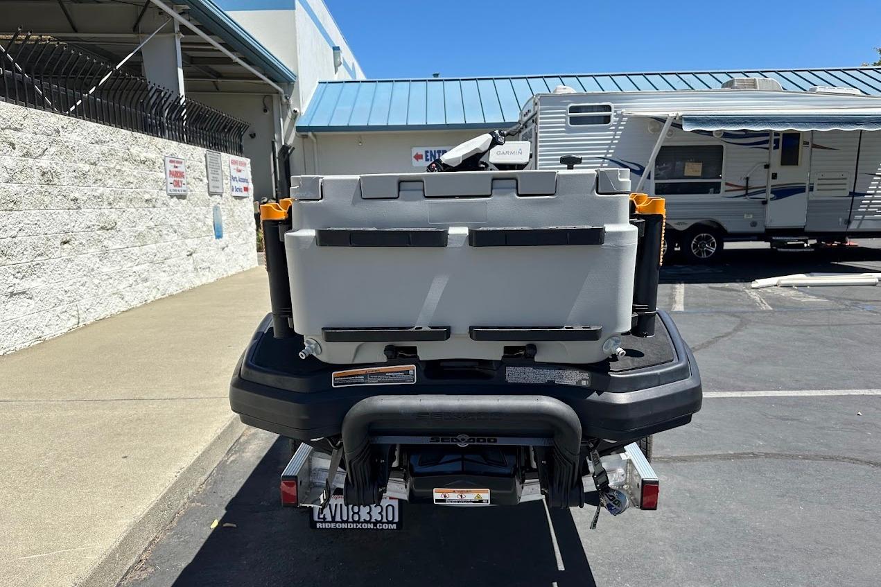2023 Sea-Doo Fish Pro Trophy with storage box, parked near RV and building.