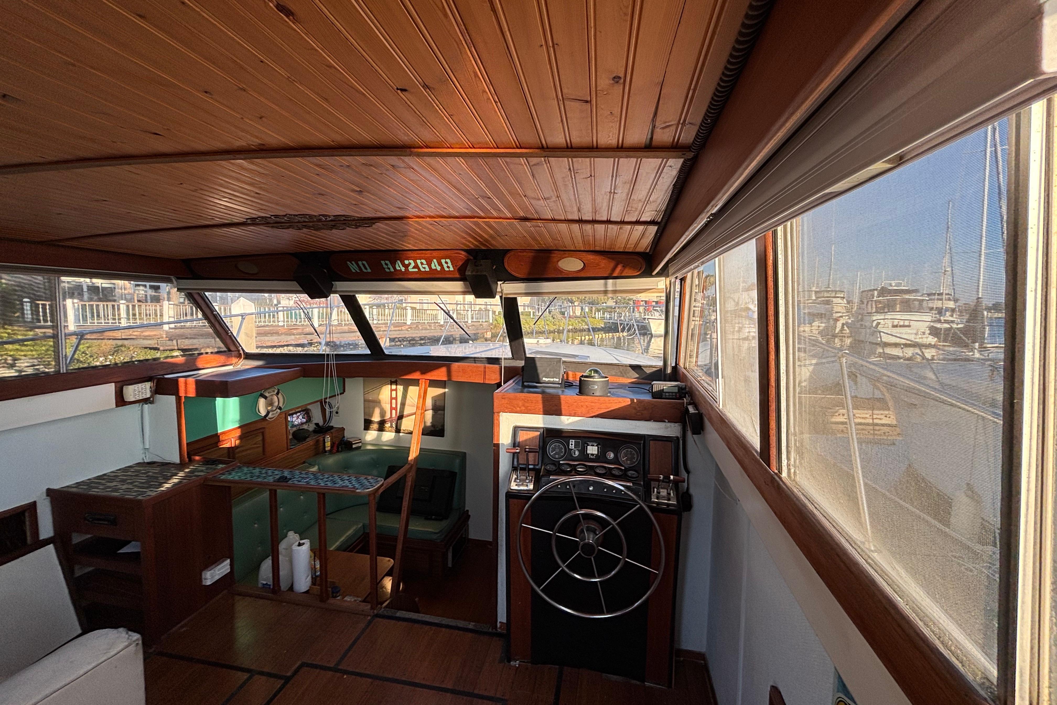 1979 Viking 43 boat interior with wooden paneling and steering wheel, docked at marina.