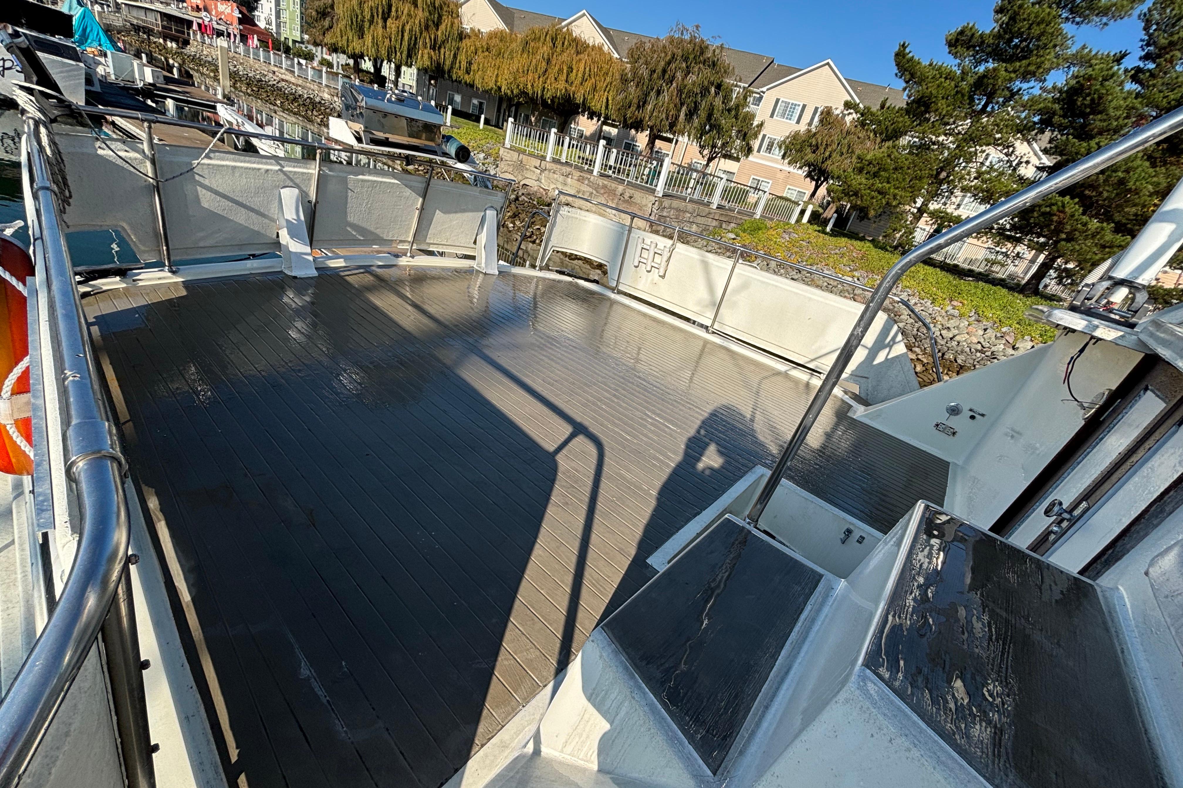 Spacious deck of a 1979 Viking 43 boat, docked near residential area.