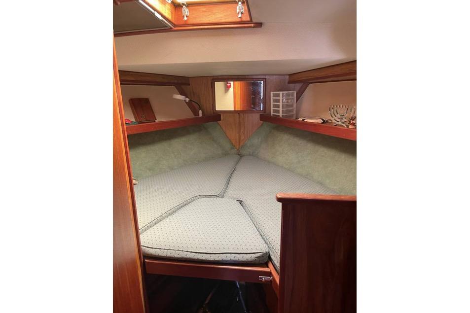 Cozy cabin interior of a 1979 Viking 43 boat with cushioned V-berth.