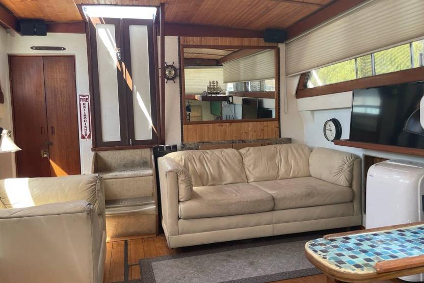 Interior of a 1979 Viking 43 yacht with beige sofas and nautical decor.