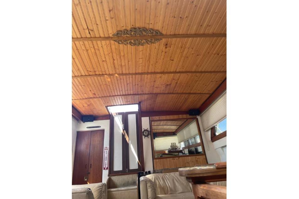 Interior of a 1979 Viking 43 boat with wooden ceiling and cozy seating area.
