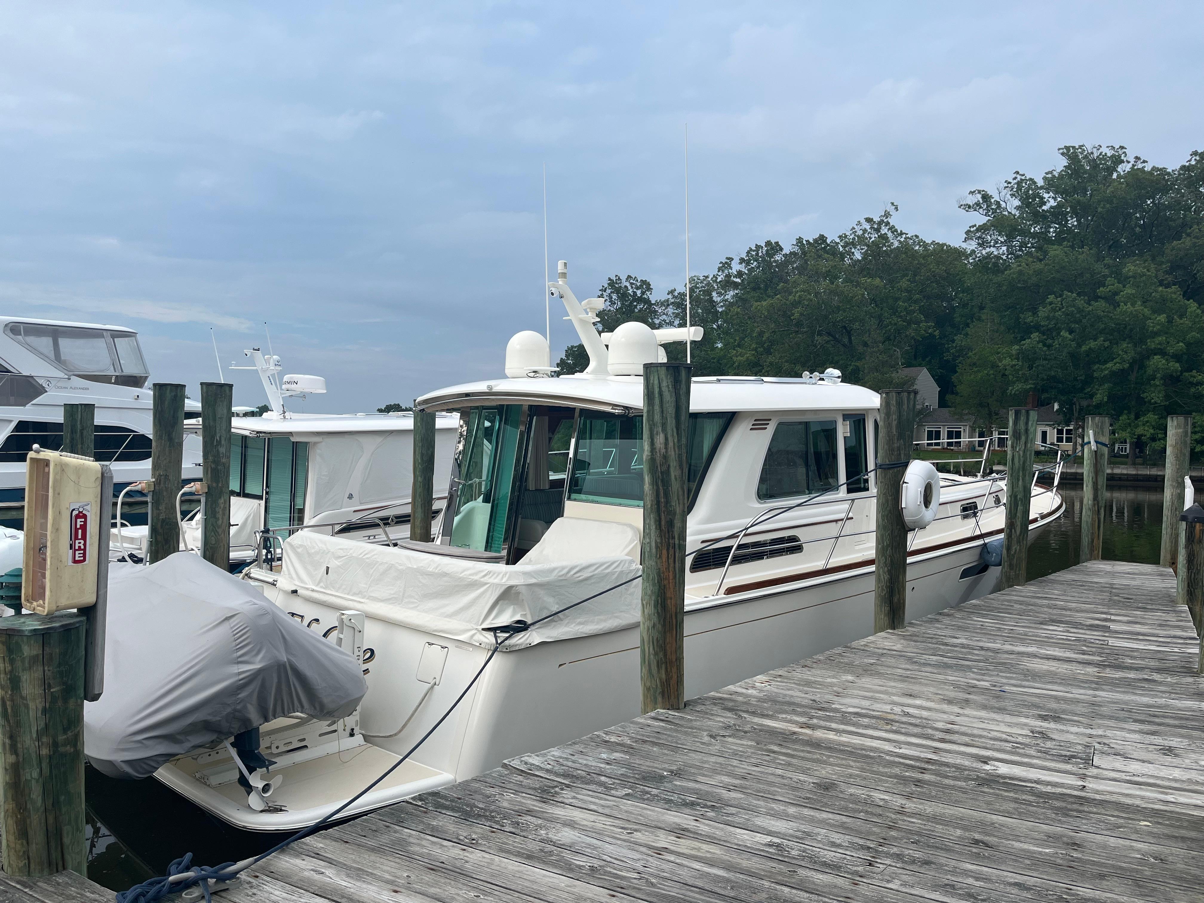 2021 Sabre 48 Salon Express yacht docked at a marina with wooden piers.