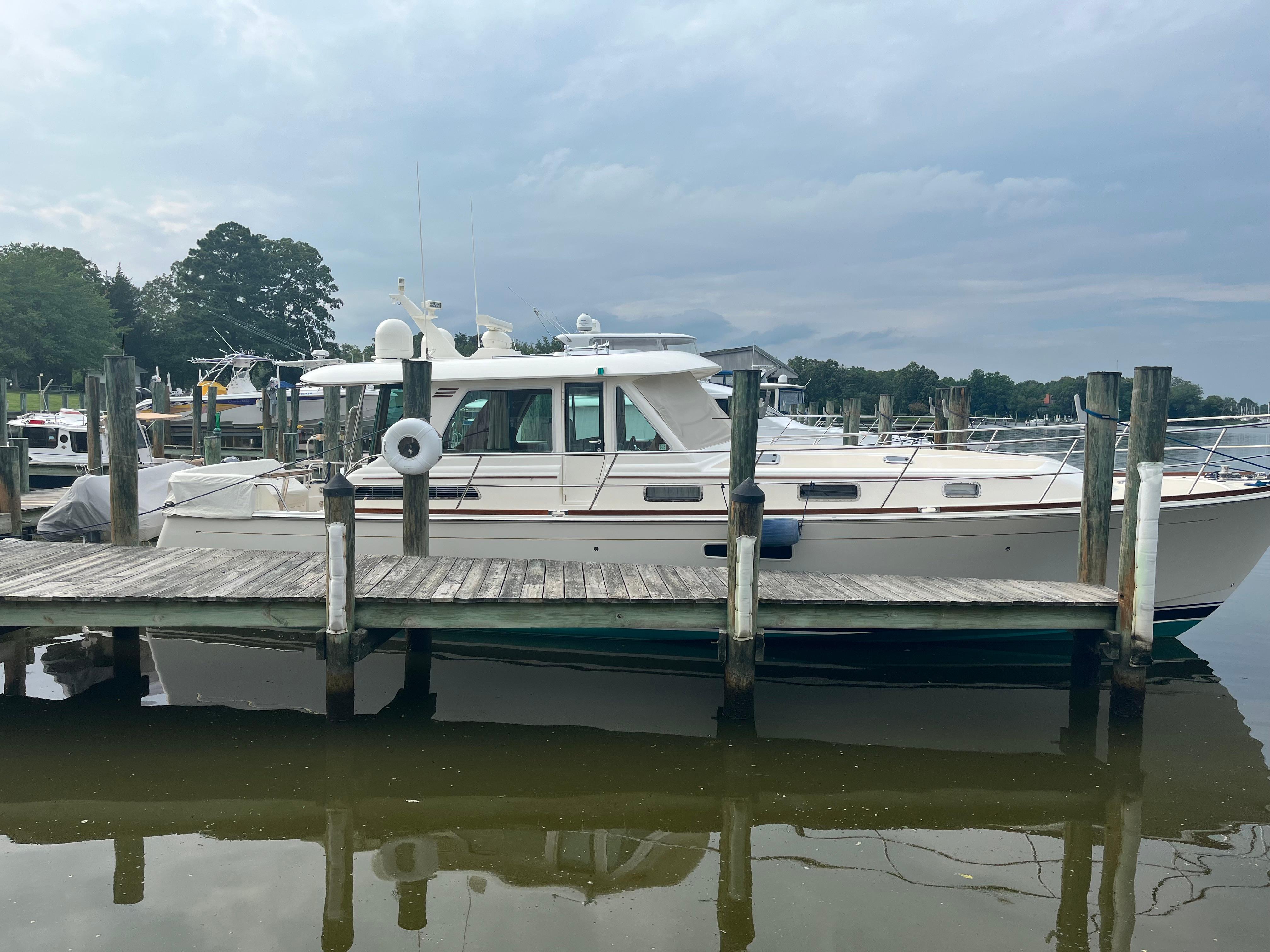 2021 Sabre 48 Salon Express yacht docked at a marina under cloudy skies.