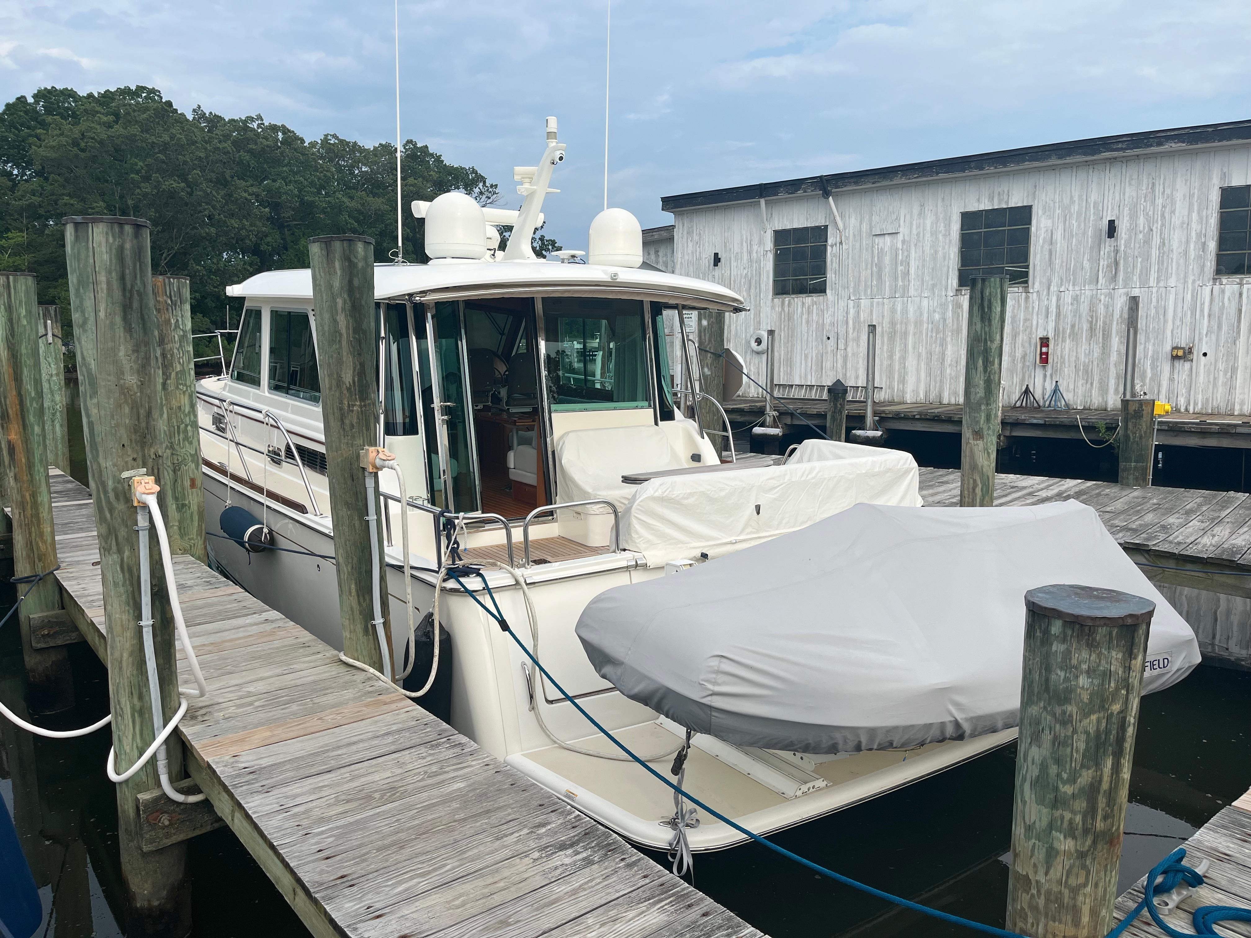 2021 Sabre 48 Salon Express yacht docked at marina with covered dinghy.