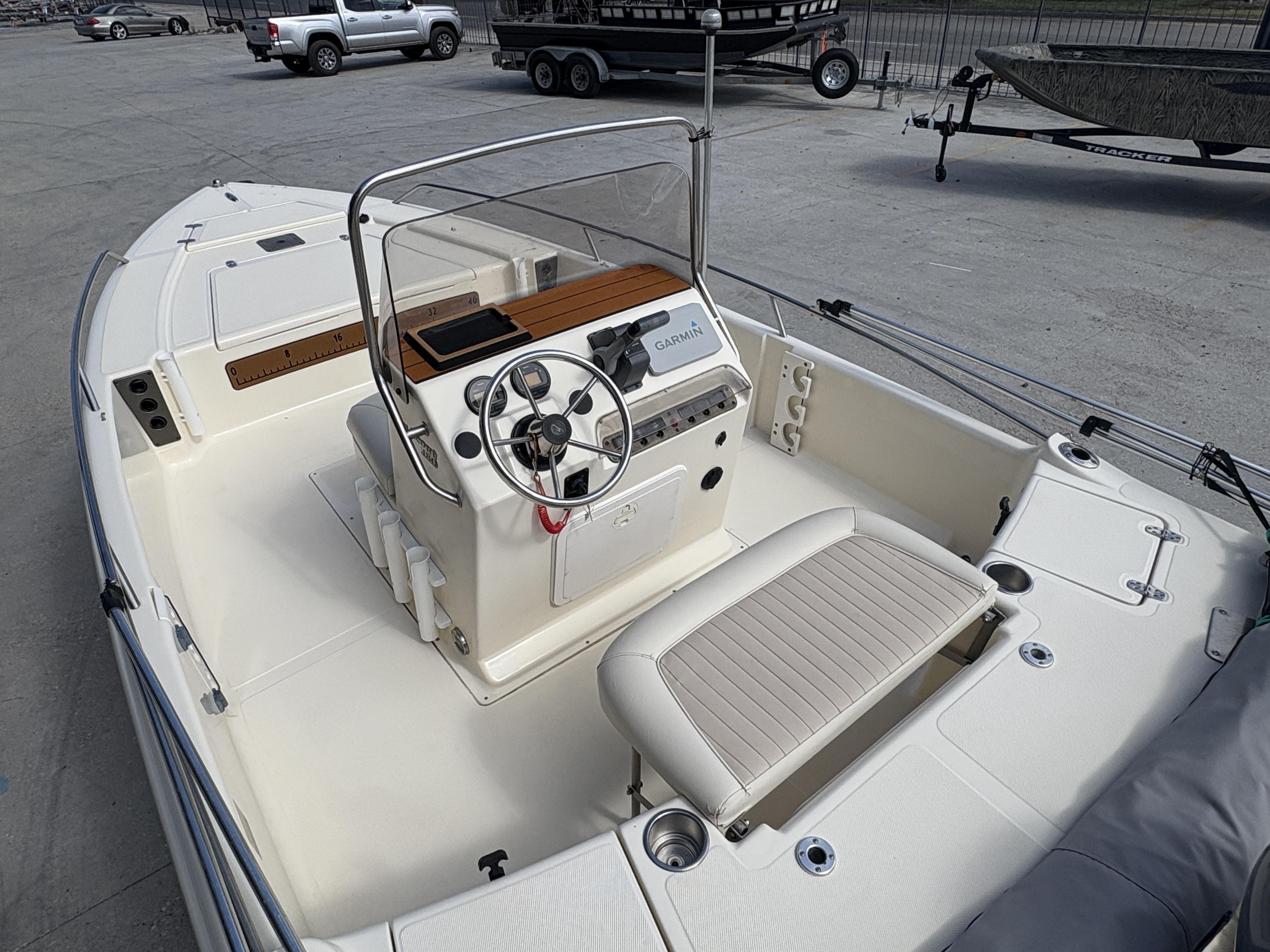 2005 Scout 17 boat interior with steering wheel and seating, parked on concrete.