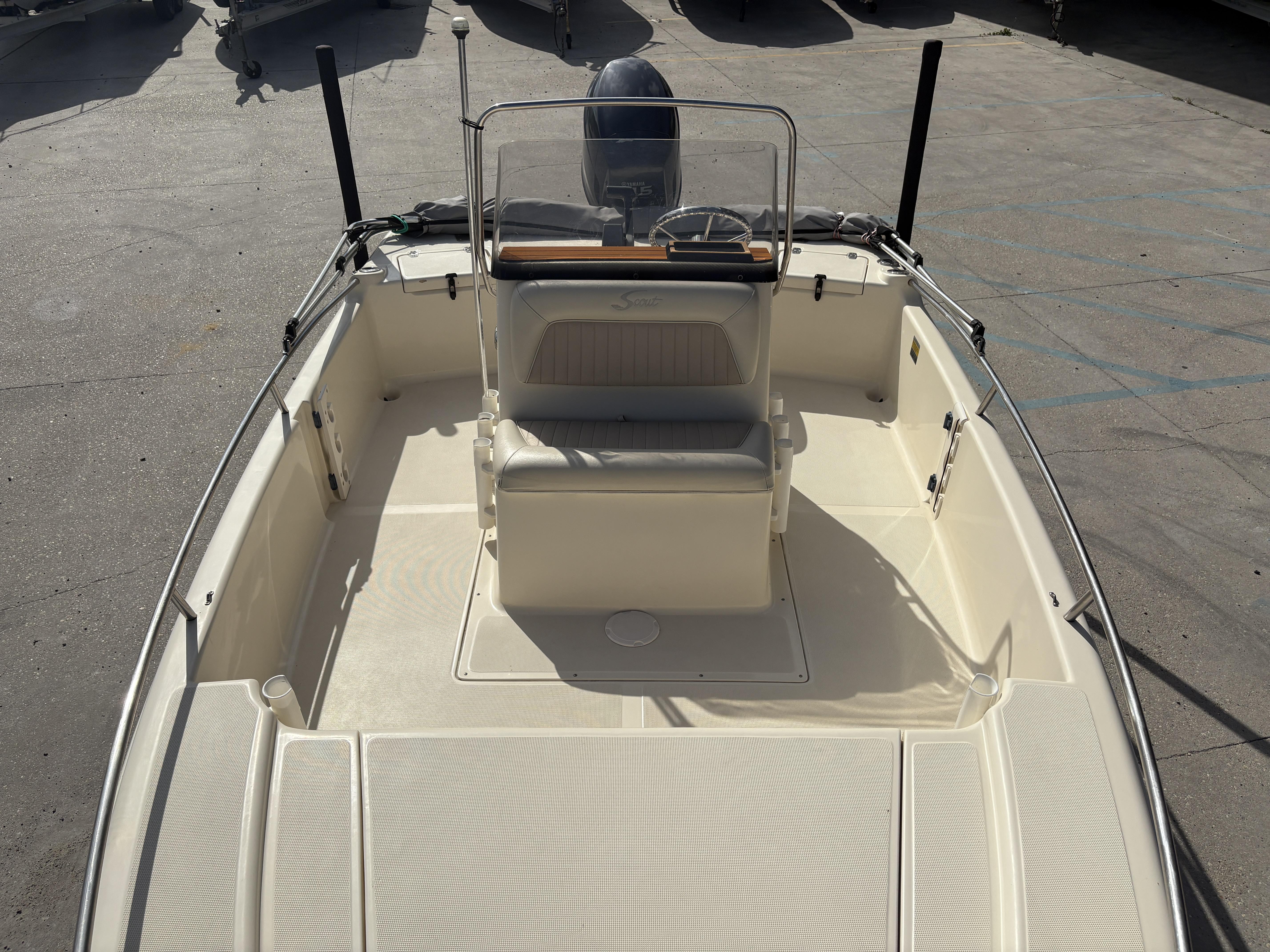 2005 Scout 17 boat interior with seating and steering console, parked on concrete.