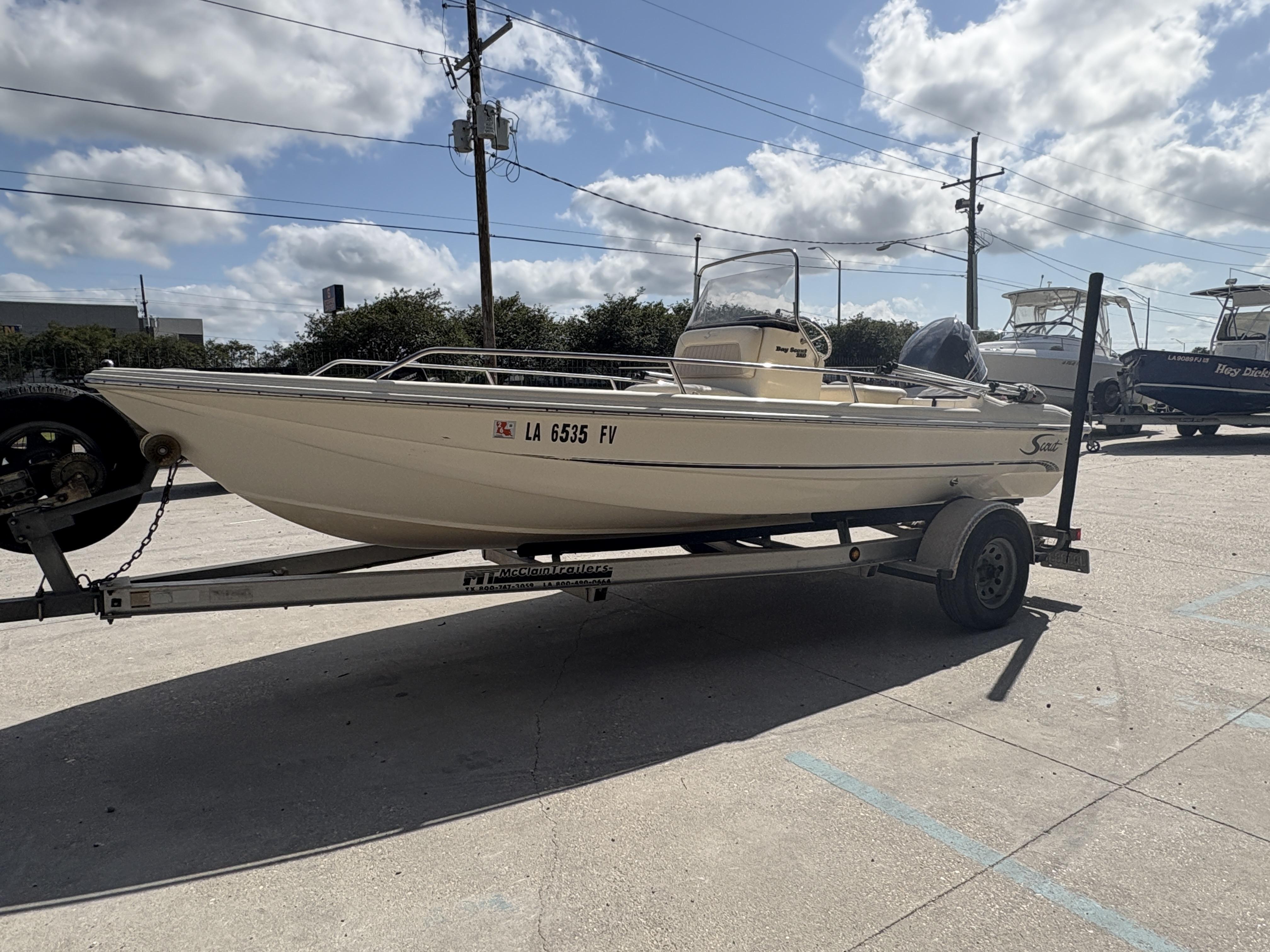 2005 Scout 17 boat on trailer under cloudy sky.