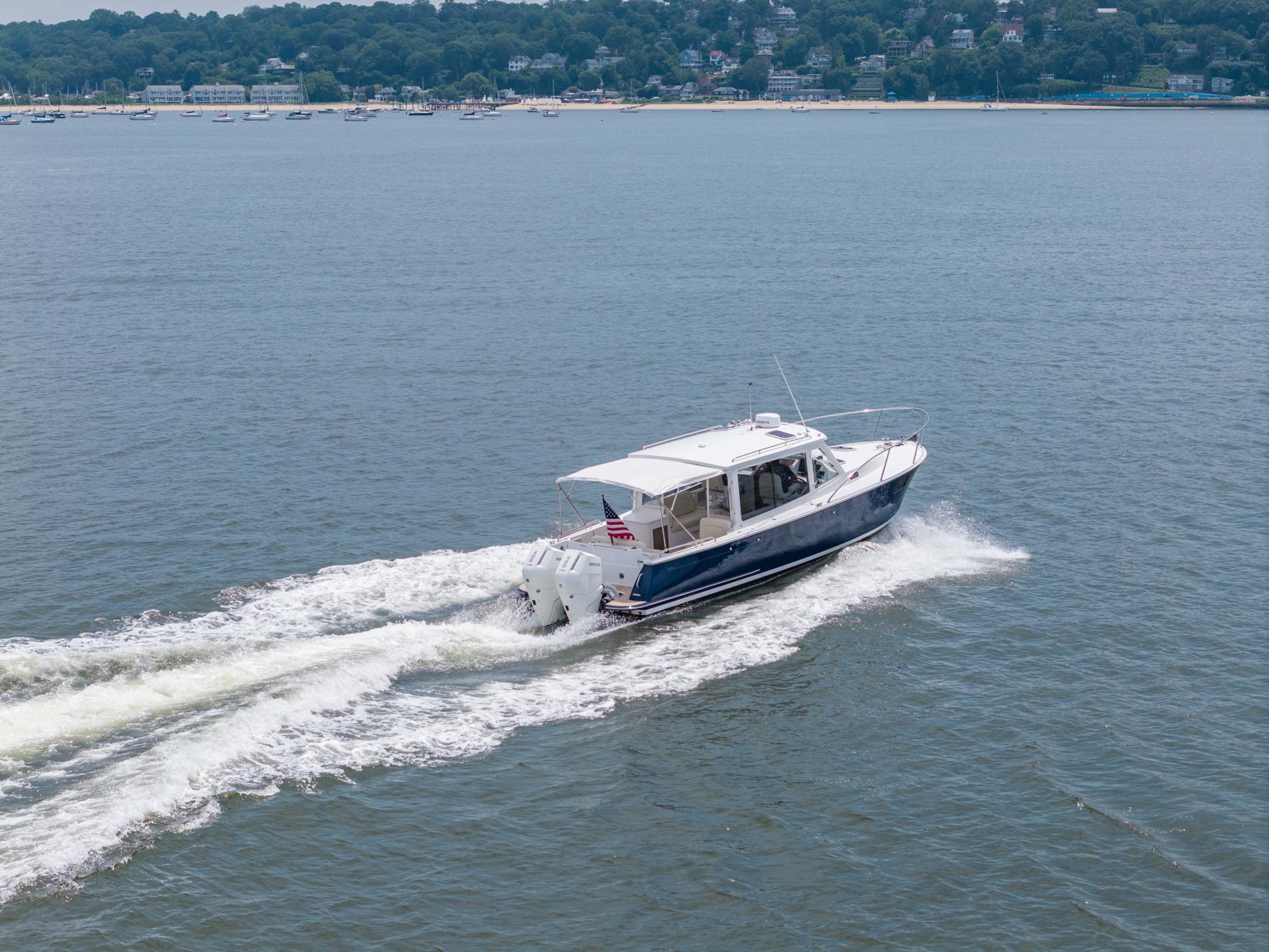 2025 MJM 35 boat cruising on open water with shoreline in background.