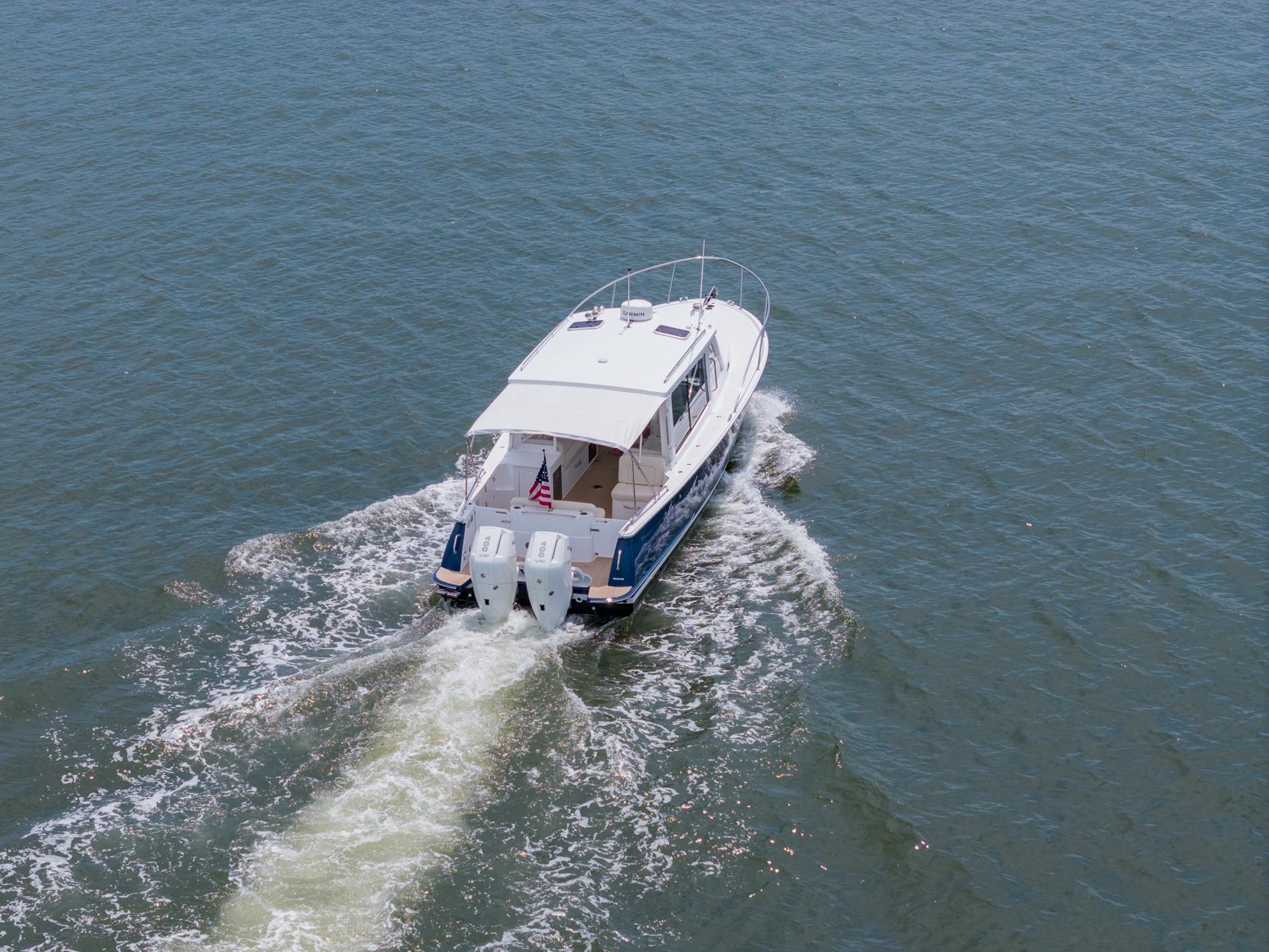 2025 MJM 35 boat cruising on open water, rear view.