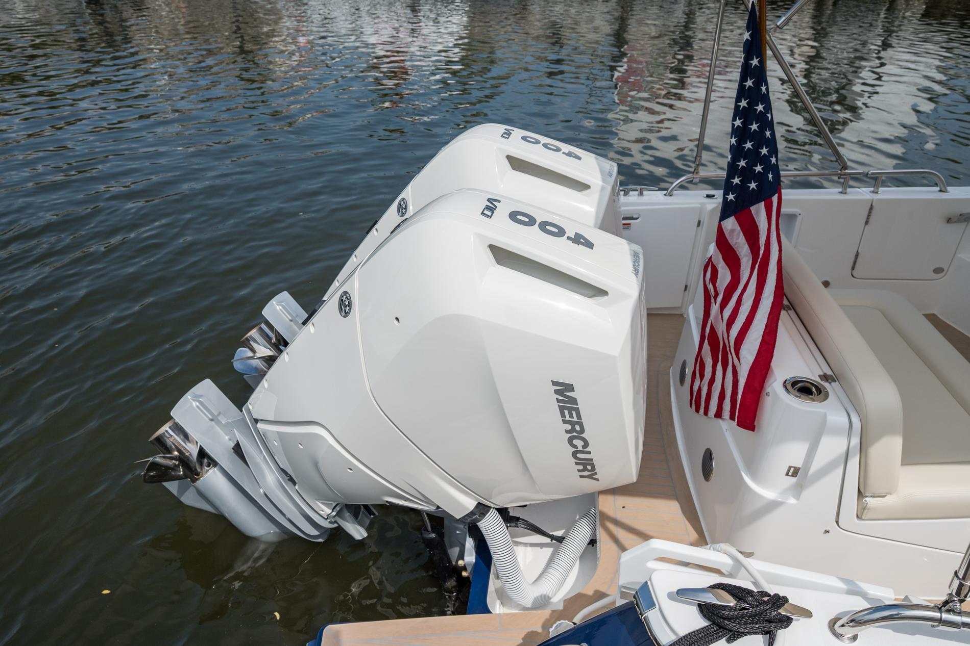 2025 MJM 35 boat with dual Mercury 400 outboard engines and American flag on water.