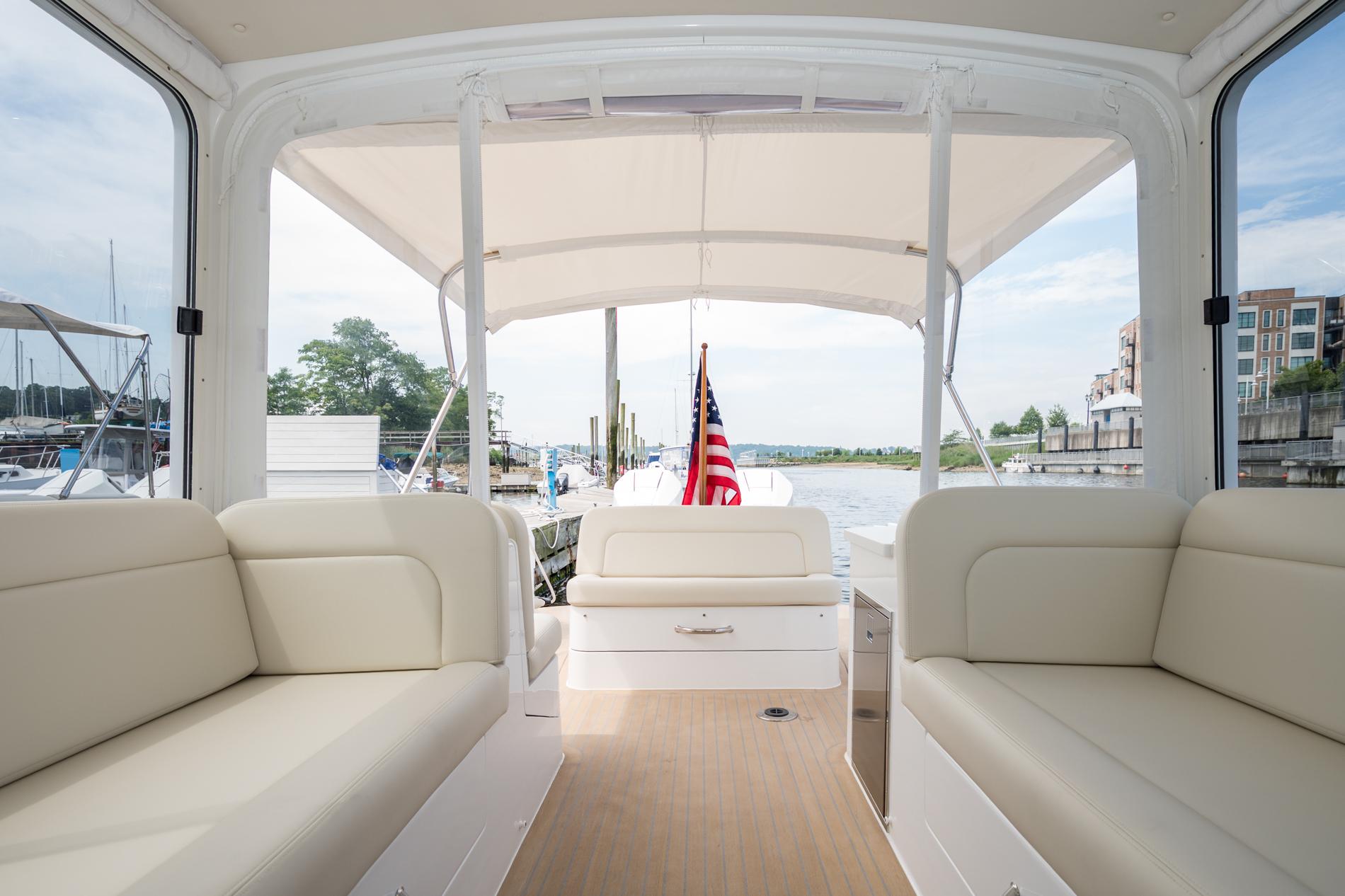 Interior view of 2025 MJM 35 boat with beige seating and American flag.