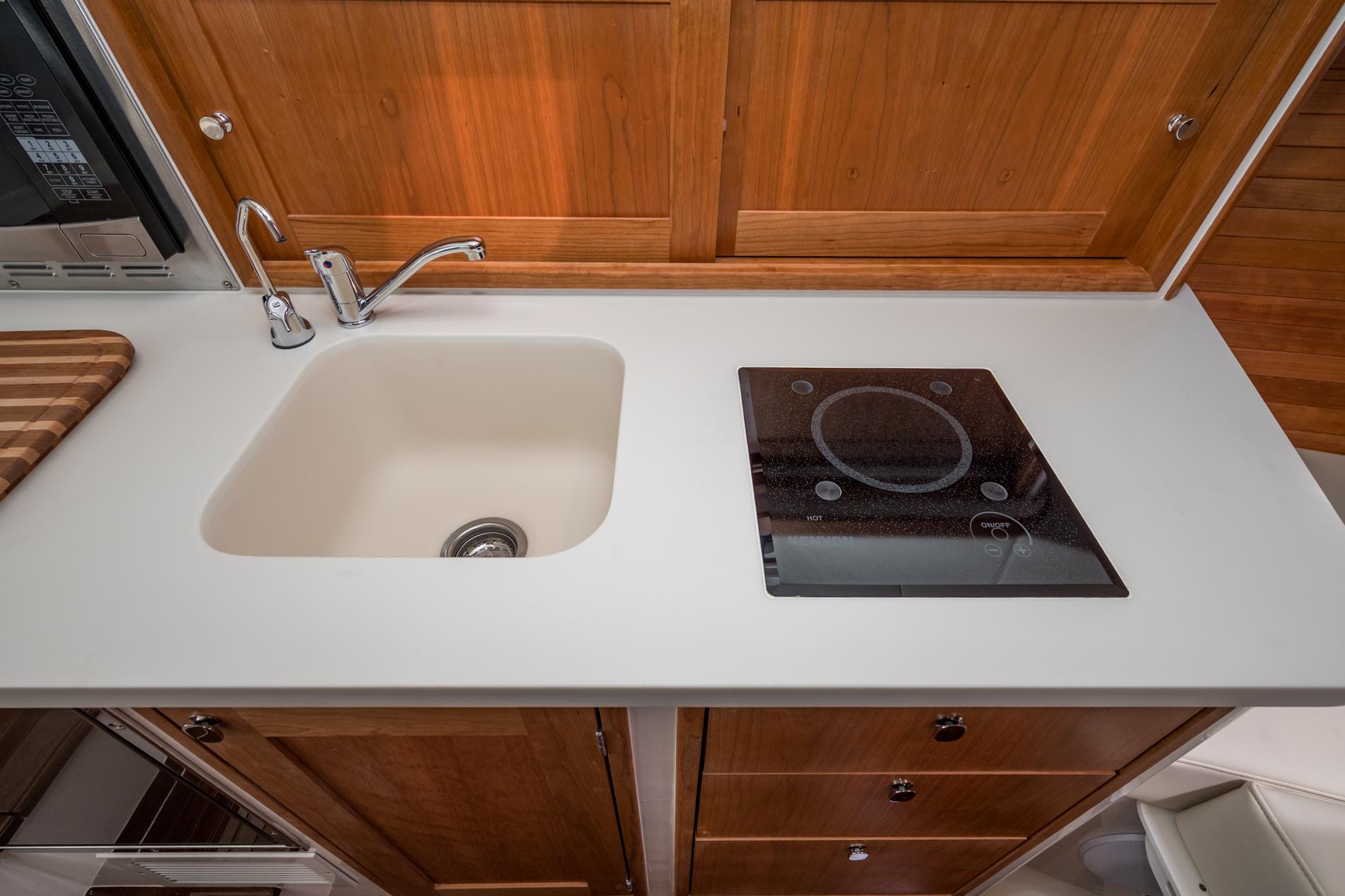 Modern kitchen area in 2025 MJM 35 boat with sink and induction cooktop.