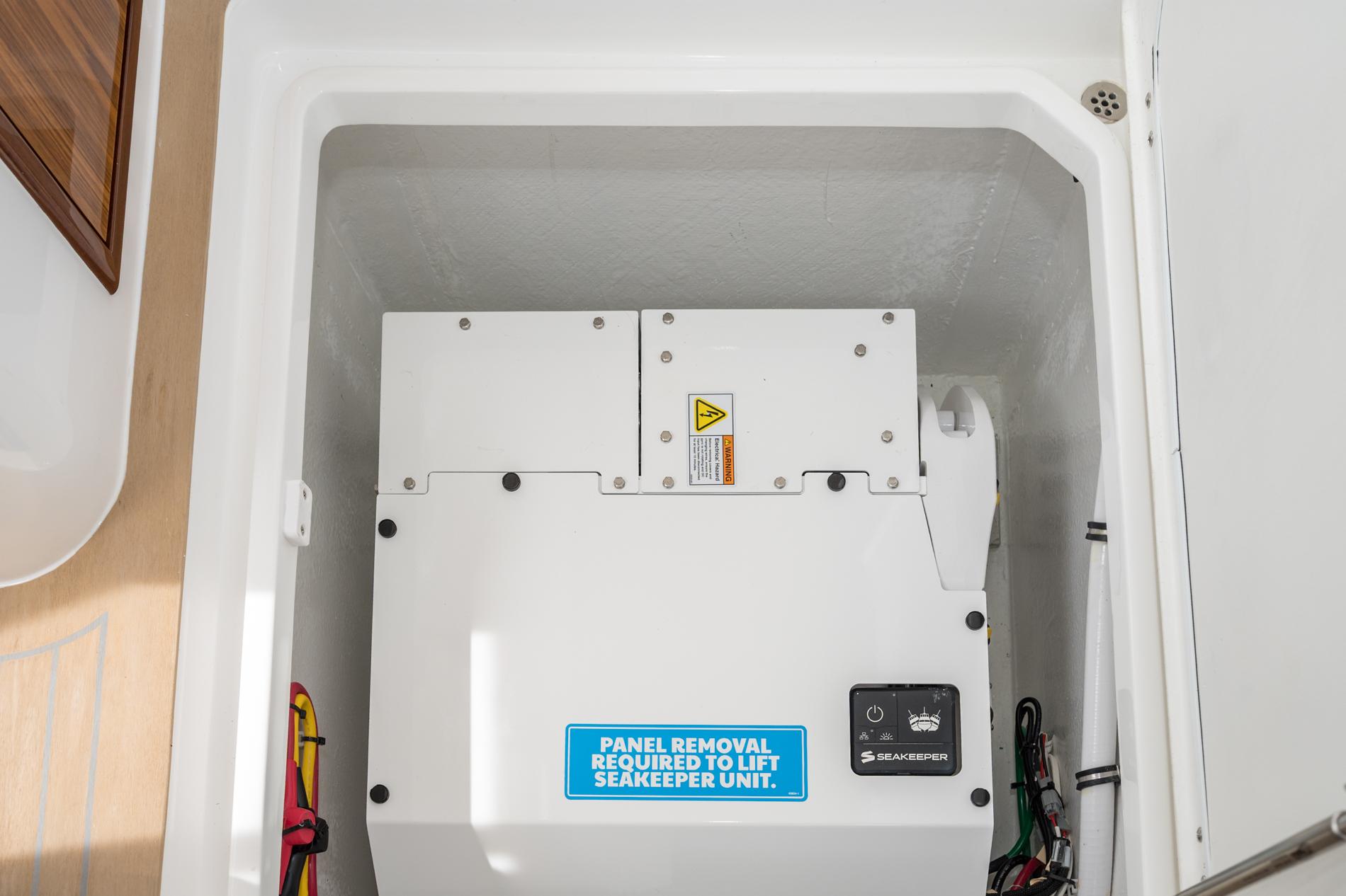Seakeeper unit in 2025 MJM 35 boat, enclosed compartment, with panel removal instructions.