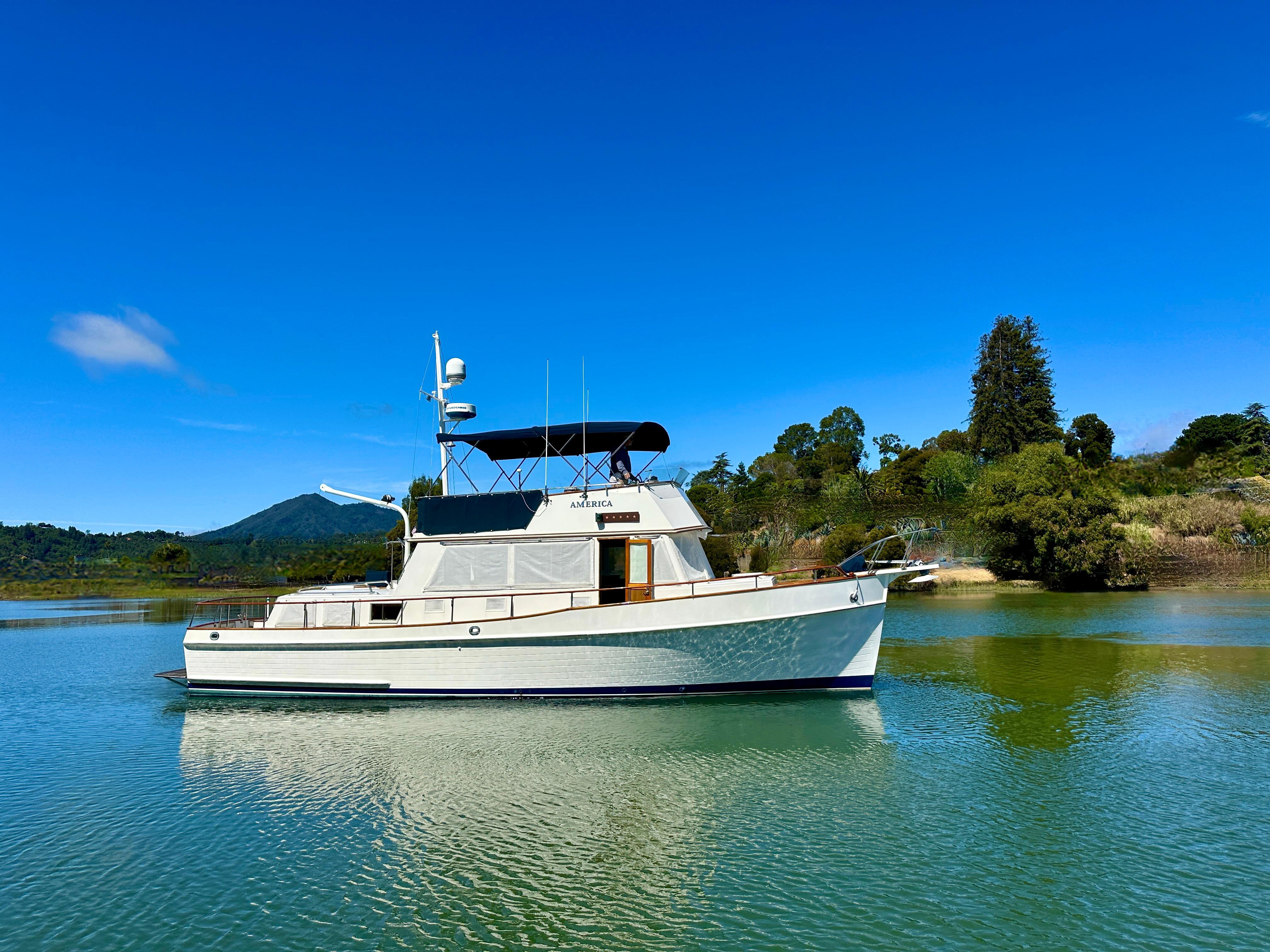 1989 Grand Banks 42 Classic yacht on calm water under clear blue sky.