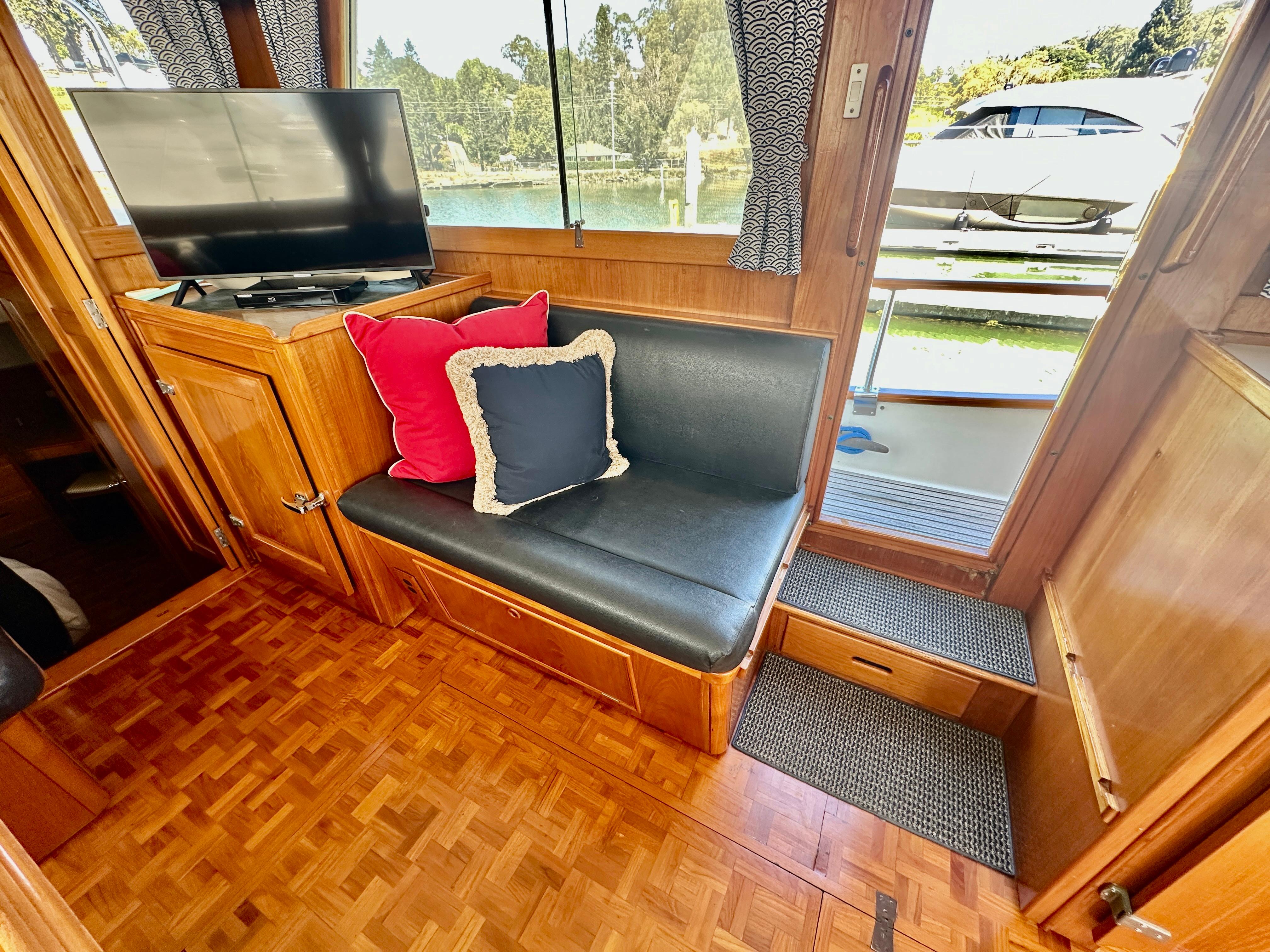 Interior of 1989 Grand Banks 42 Classic yacht with seating, TV, and scenic view.