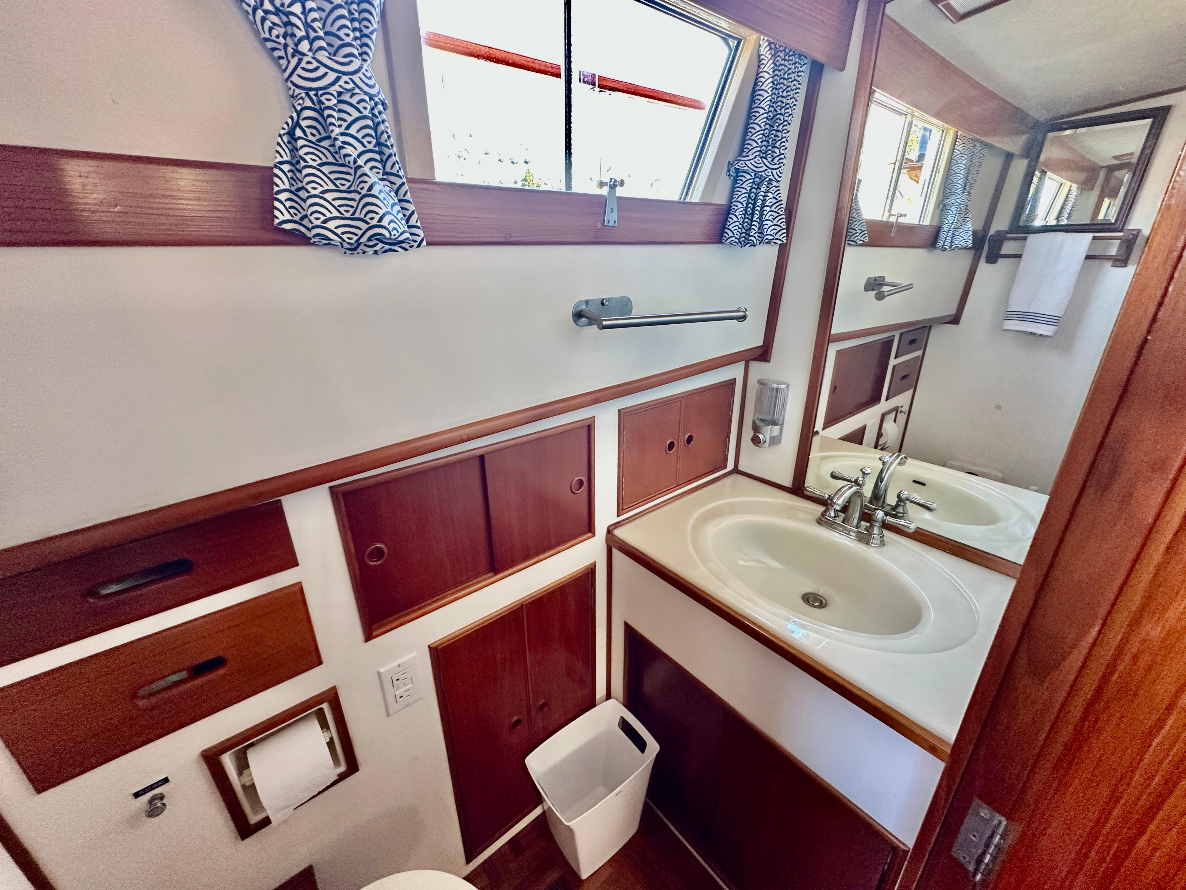 Bathroom interior of 1989 Grand Banks 42 Classic yacht with wood accents and nautical decor.