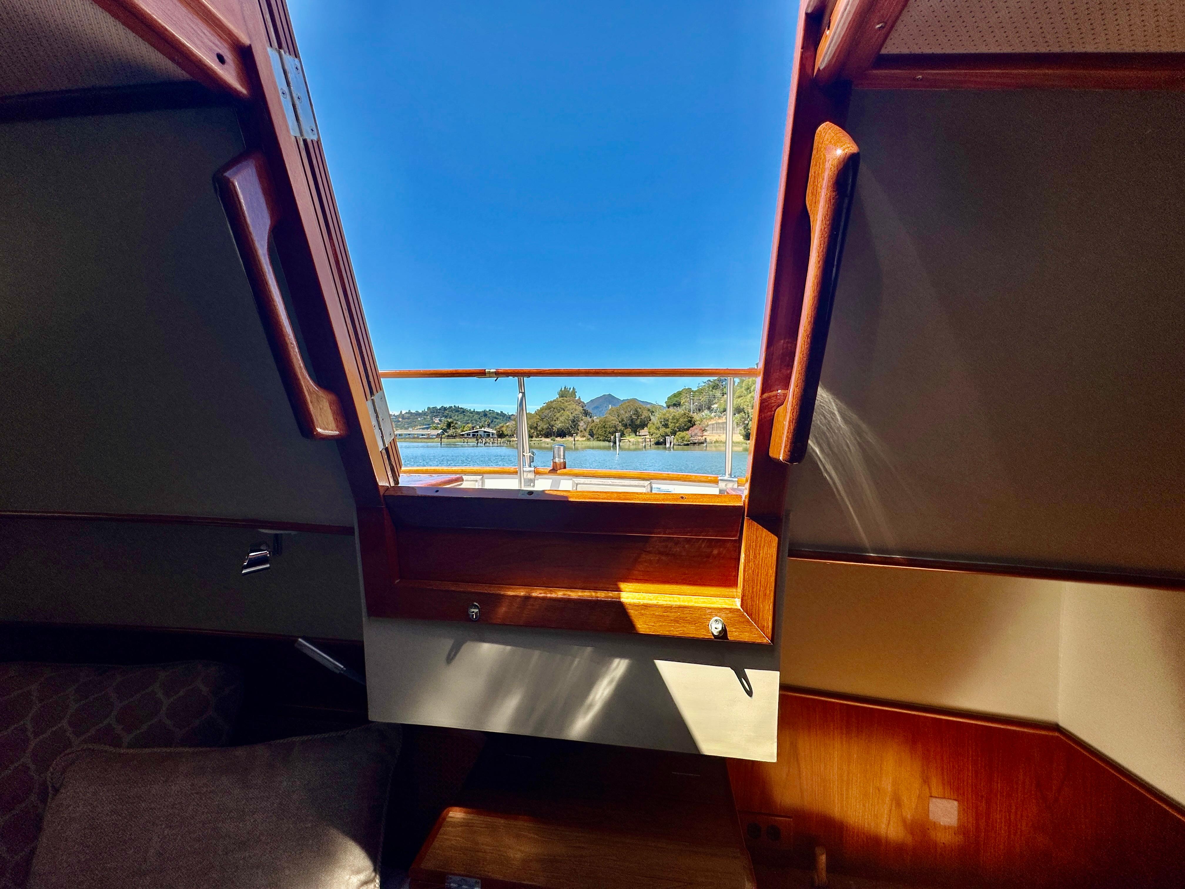 Interior view from a 1989 Grand Banks 42 Classic yacht, showcasing a scenic waterway.