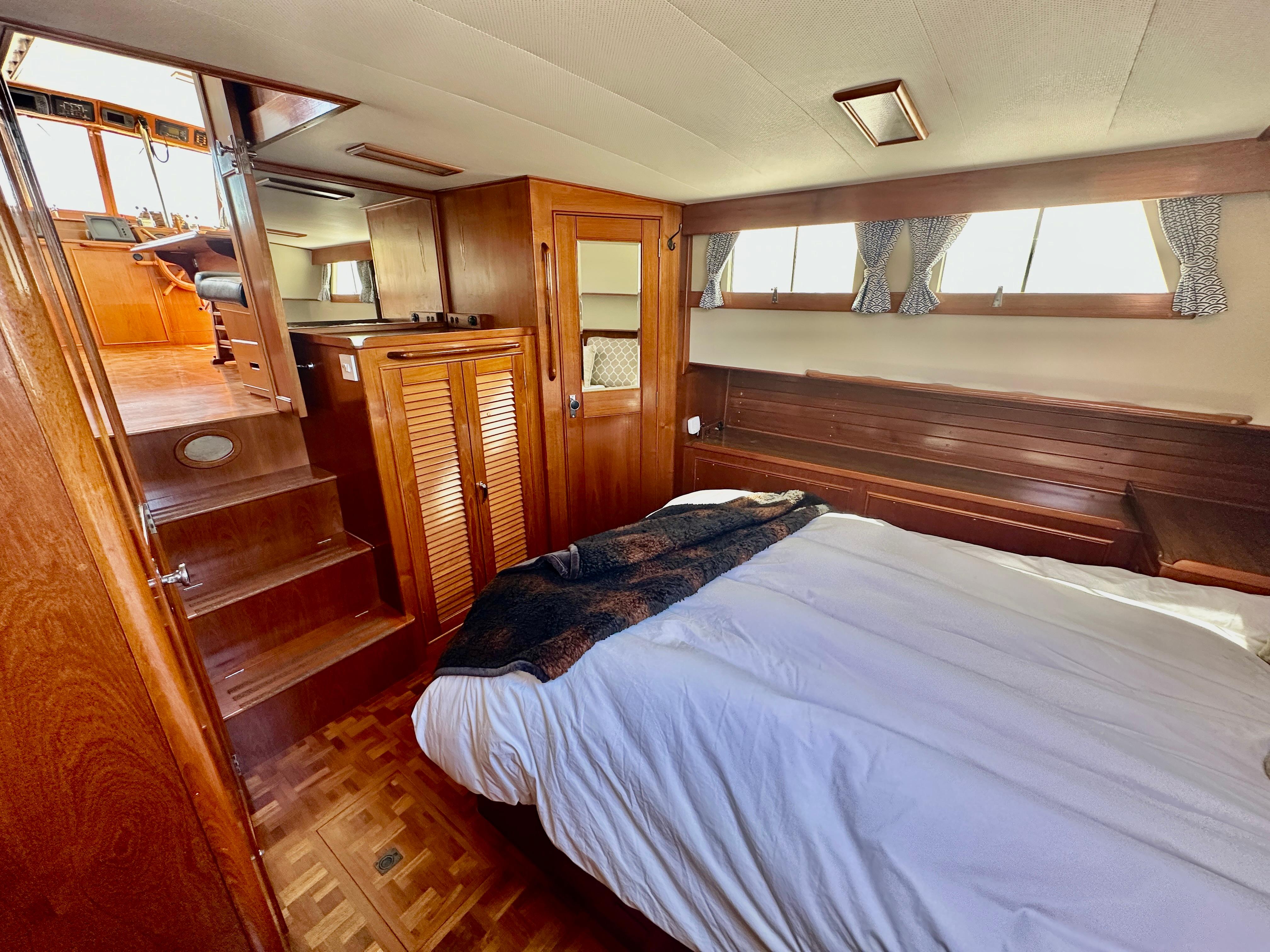 1989 Grand Banks 42 Classic yacht interior with wooden furnishings and cozy bedroom.