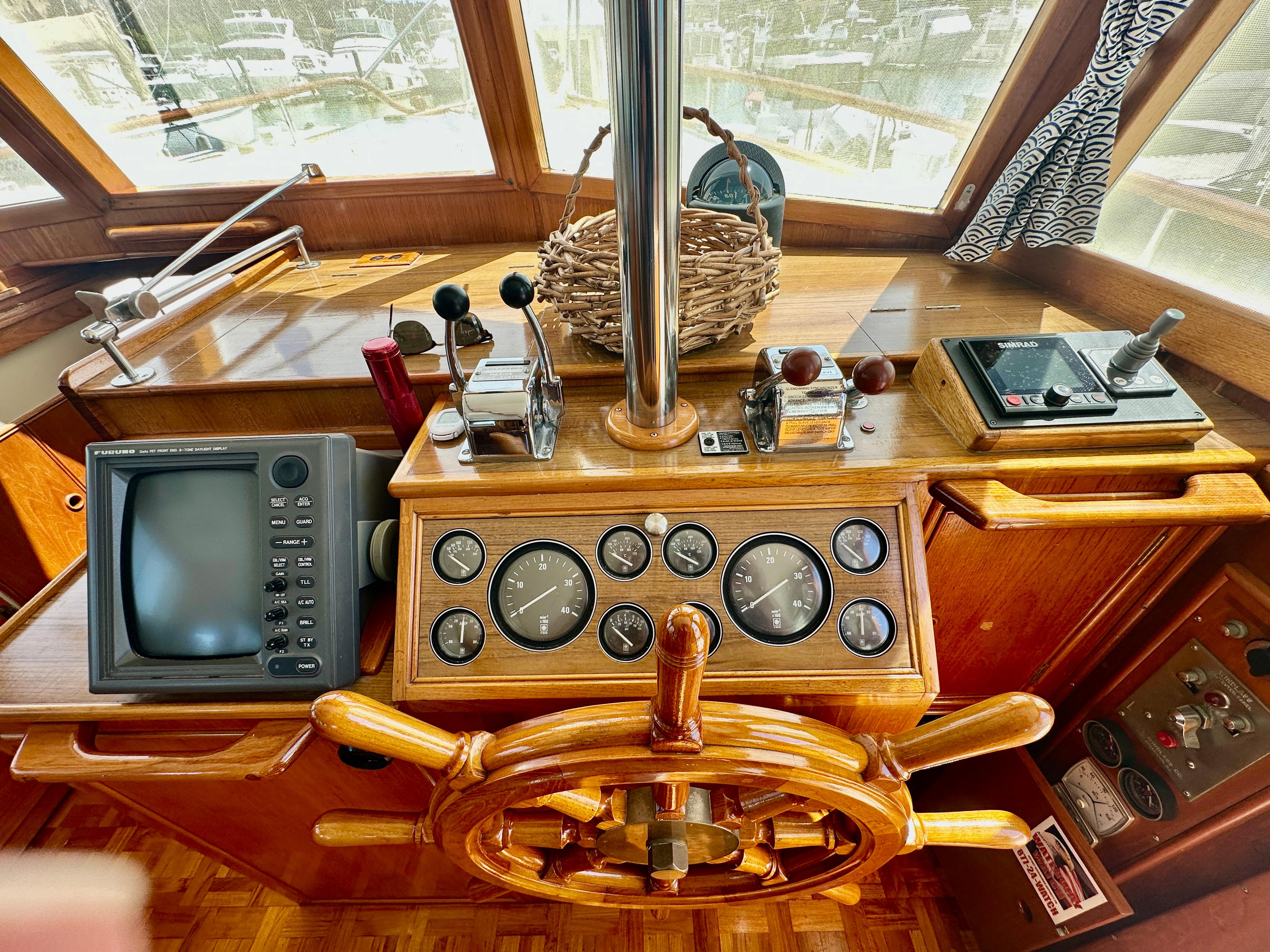 Helm of 1989 Grand Banks 42 Classic yacht with wooden wheel and navigation instruments.
