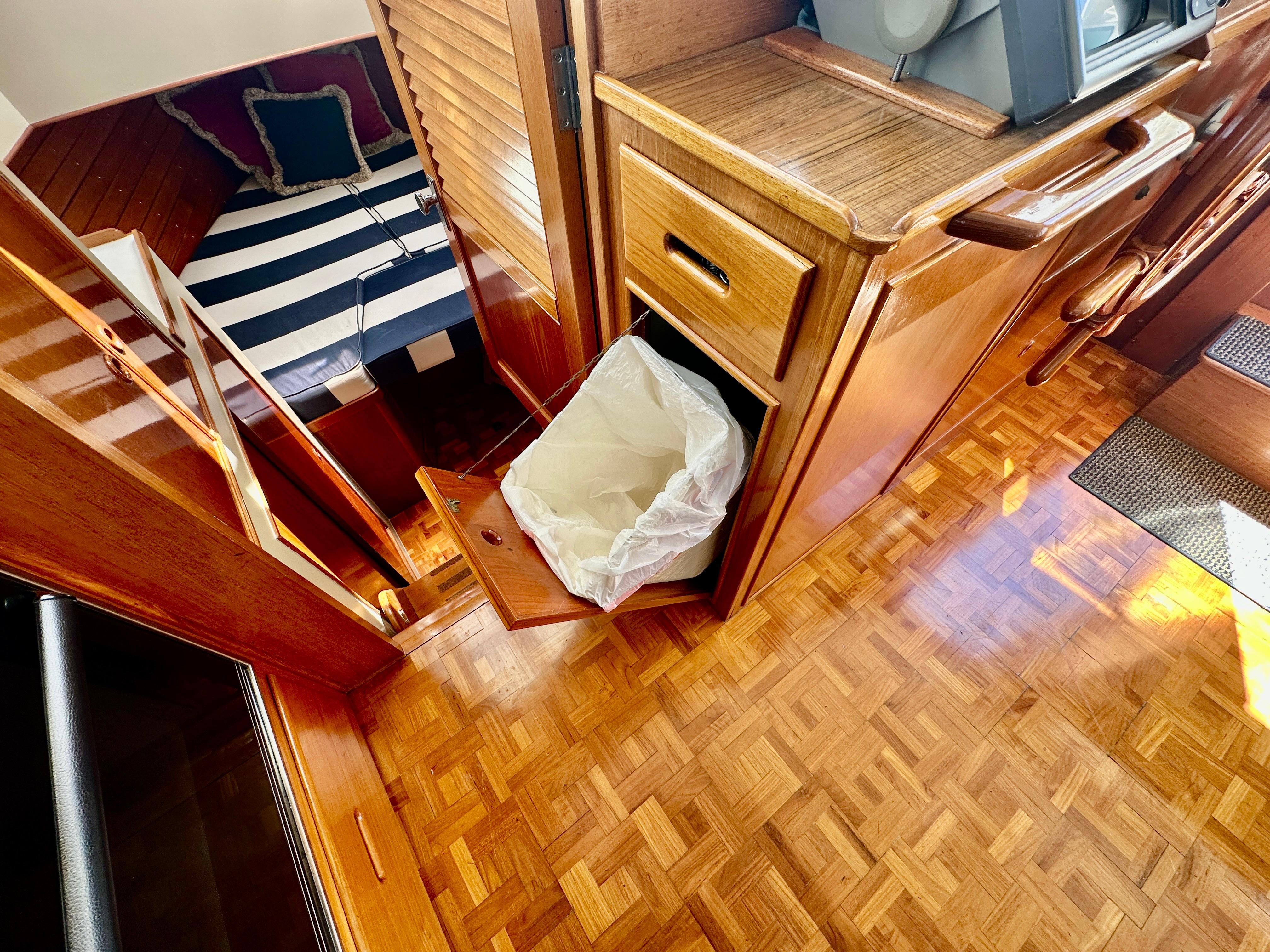 Interior of 1989 Grand Banks 42 Classic yacht with wood finish and striped bedding.