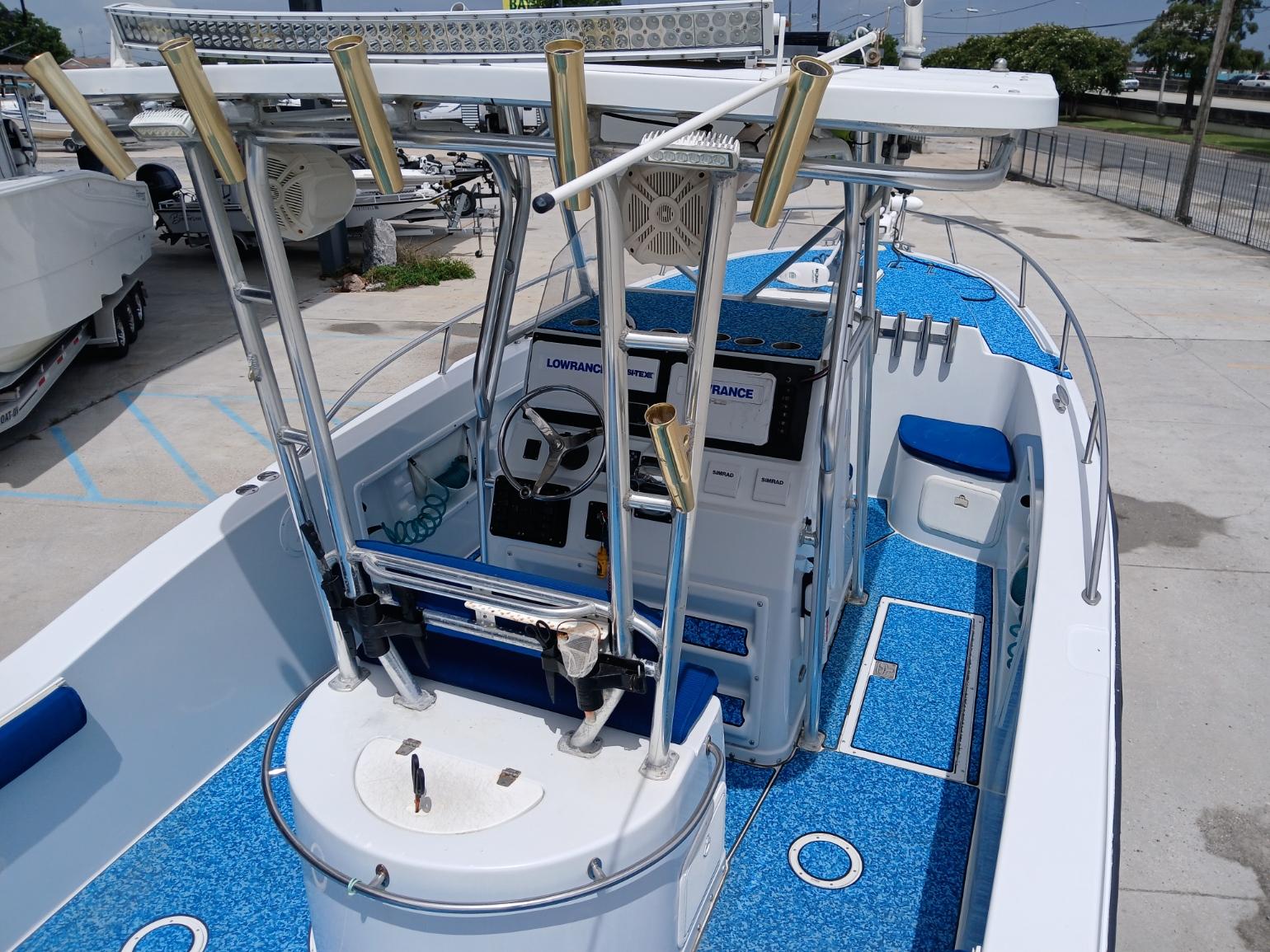 2002 ProKat 2860 Center Console boat with blue deck, rod holders, and navigation equipment.